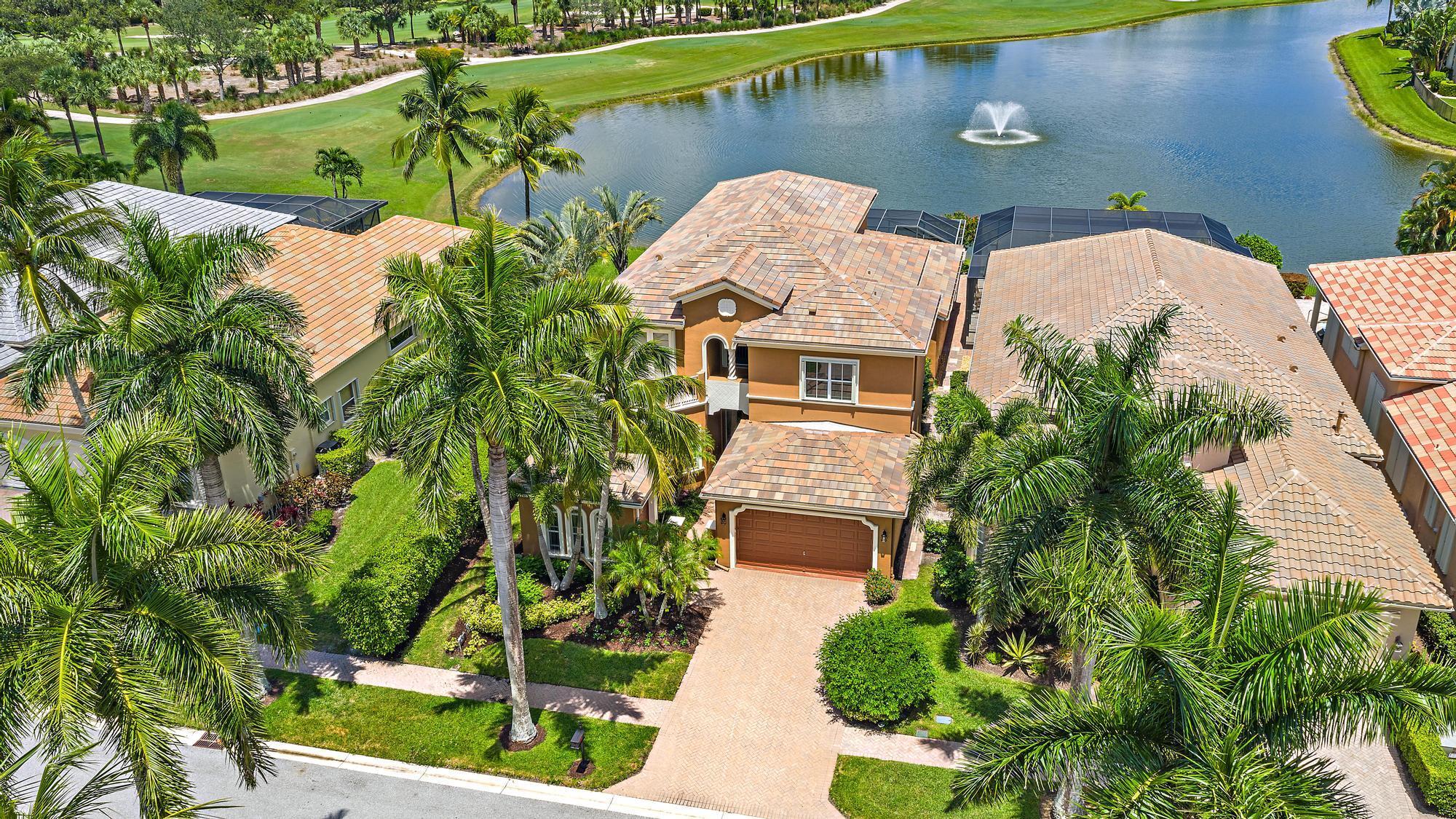 IMMEDIATE PREMIER GOLF MEMBERSHIP AVAILABLE. This spacious and upgraded 4BR/3.5BA+Den ''Martinique'' model offers one of the most dramatic water and golf views in all of South Florida. Designed to impress, the home features soaring 22-foot ceilings that frame breathtaking vistas both inside and out, creating a light-filled, open feel throughout.Recent major upgrades provide peace of mind for the new owner, including a brand-new 2025 roof, two new HVAC systems (installed December 2023), and a whole-house 22KW Generac generator with transferable warranty. Accordion shutters and clear storm panels add an extra layer of protection, ensuring the home is fully prepared for all seasons. The outdoor living space is equally impressive.