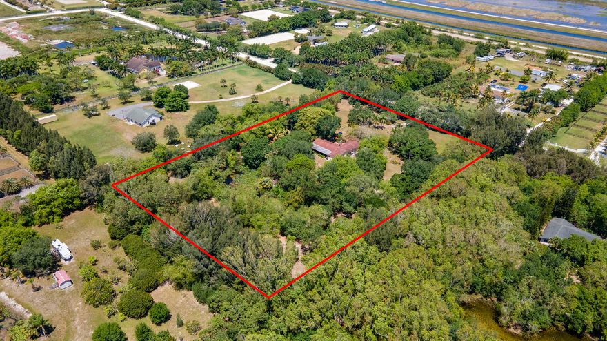 Discover the perfect canvas for your equestrian dream home in highly coveted Rustic Ranches subdivision of Wellington. This exceptional property spans 5 acres of prime equestrian land, offering a unique opportunity to design and build bespoke mansion tailored to the most discerning tastes. Included in this offering is a 2,986 sq ft home, ready to be transformed into a stunning residence that epitomizes luxury and comfort. Envision adding personalizes stables and paddocks, creating an idyllic environment for both horse and rider. The land is adorned with majestic 40-Year-old Florida native fruit trees, a serene pond, and tranquil surroundings that promise a peaceful retreat from the bustling world.