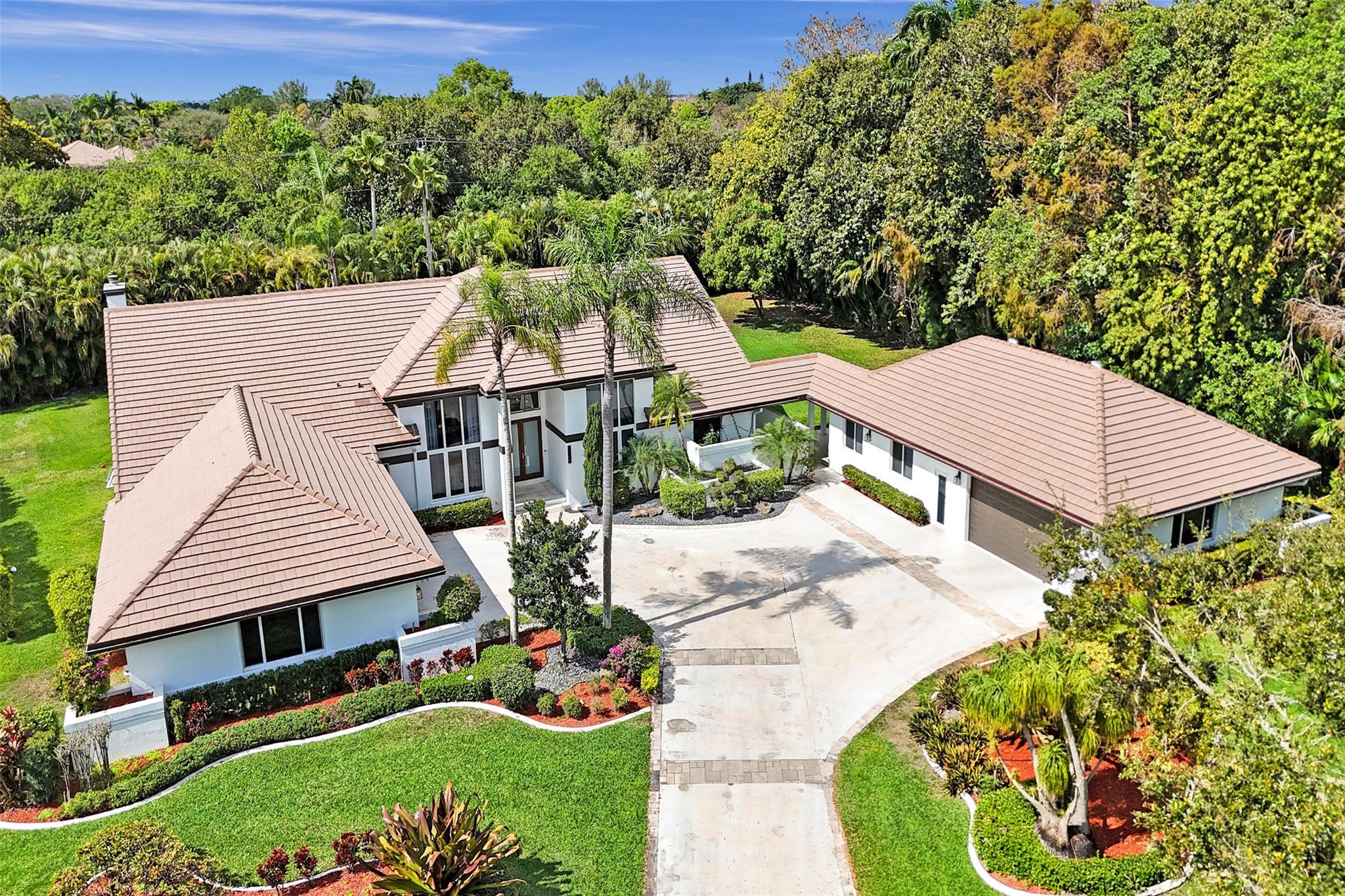 Absolutely Perfect! This beautifully updated estate home features impact windows and doors and a split floor plan that provides privacy and flexibility, making it ideal for families of all sizes. Flooded with natural light, the home boasts stunning marble flooring, a sleek new white kitchen, and a striking stacked-stone fireplace. The resort-style outdoor space features a refreshed pool and spa, marble pavers, and a summer kitchen—perfect for family gatherings and entertaining. A separate guesthouse adds even more versatility for extended family or visiting guests. With impressive exterior charm and a spacious backyard, this home is a rare gem! CONCRETE ROOF 10yrs old, 3 NEWER AC's (2 yrs old), BRAND NEW H/W HEATER, HURRICANE IMPACT THRU OUT!!