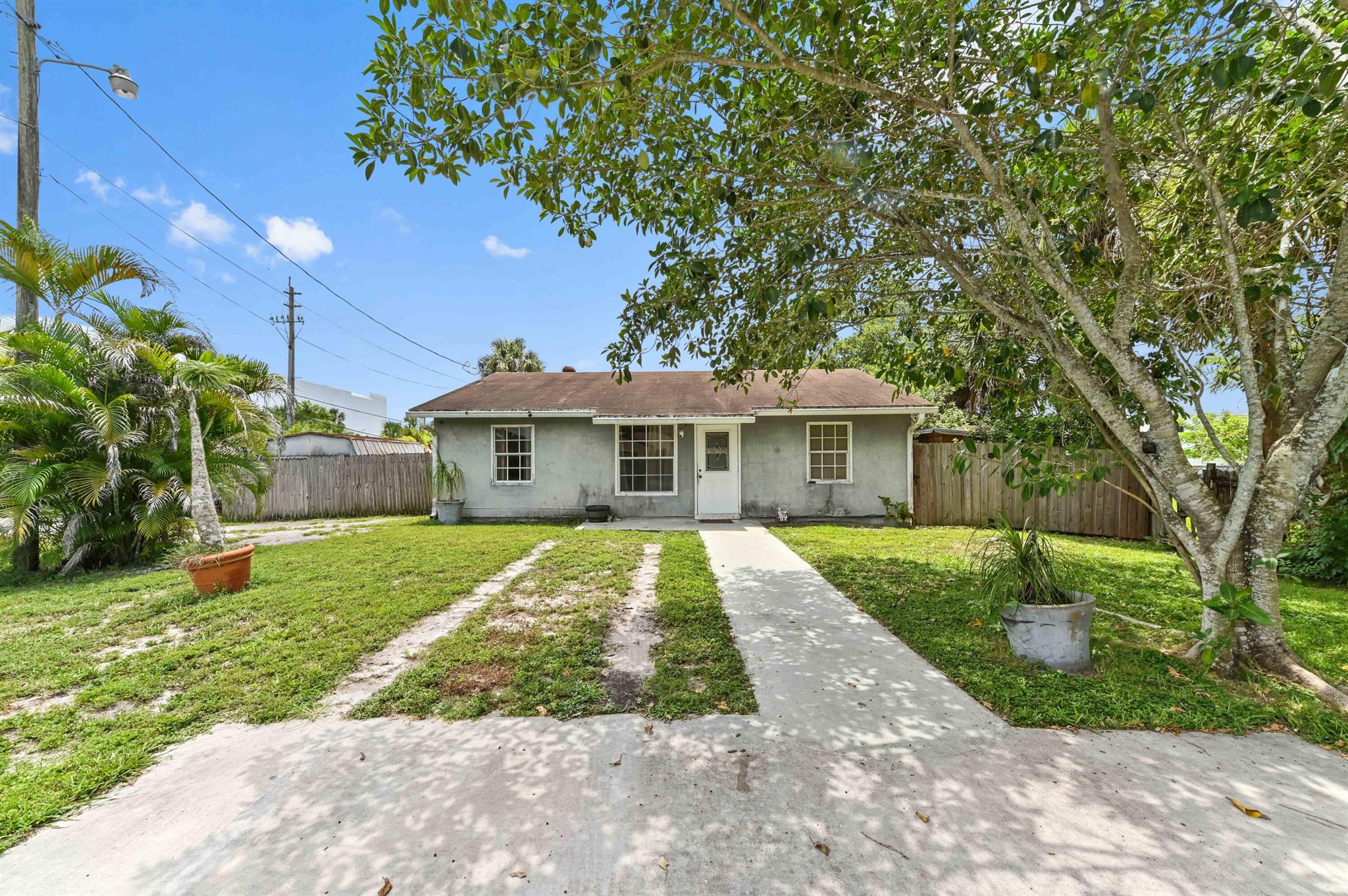 Discover a true sense of freedom and space in this charming single-family home, perfectly positioned on a generous corner lot within the non-HOA community of Palm Beach Farms in West Palm Beach, FL. This inviting residence features 3 comfortable bedrooms and 2 full bathrooms, offering a practical and serene living environment. Step inside to a welcoming living room that seamlessly flows into the combined dining and kitchen area, creating an open and connected heart of the home. The kitchen is both functional and stylish, boasting a classic tiled backsplash and a convenient laundry/storage closet for added utility.