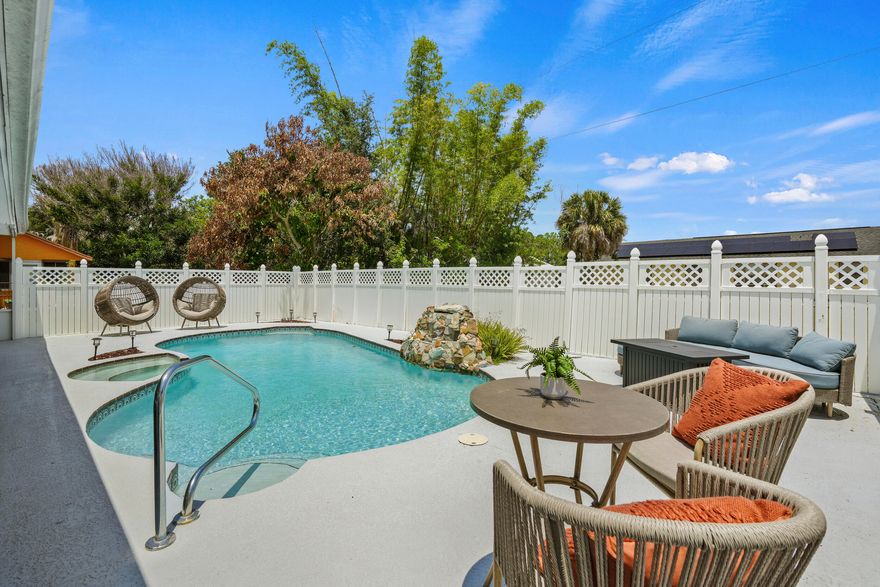 The easy-going feel of this home begins with its spacious circular driveway offering plenty of room for family and friends when they arrive to enjoy the relaxing vibe of your updated pool/spa home. Amazing outdoor entertaining space complete with a waterfall feature. This home had a quality remodel in 2024 giving it a modern feel with luxury vinyl plank flooring throughout. The classic u-shaped kitchen, open to the family room, shines with white shaker cabinets, deep granite countertops, SS appliances and a large pass-through window for serving your party guests. The family room opens to the 37 x 12 screened lanai providing plenty of space for casual seating and dining areas. The large living room offers additional space for family gatherings. But Wait!! There's  With the split floorplan, guests have the privacy of two BR's with a separate cabana guest bath, while the main BR has French doors opening to a covered patio and a full ensuite bathroom. The new mini-split AC in the garage offers man-cave potential. Roof 2023, A/C 2024, new insulation 2024, new pool equipment 2024, H2O Heater 2016. Centrally located with easy access to Florida's Turnpike and I95. Start planning your summer parties now!