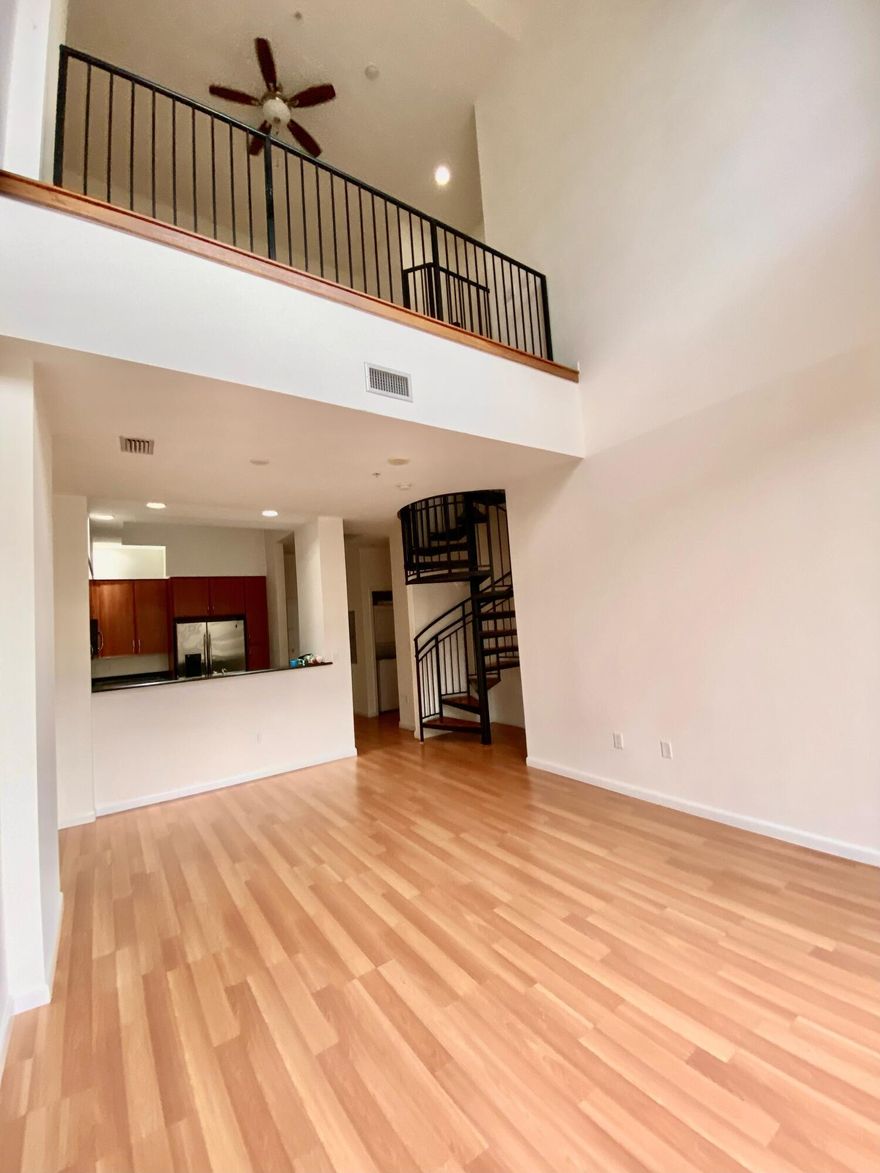 Incredible, east-facing 1 bedroom, 1.5 bath, 2 story loft in the heart of Downtown. This space is light & bright with soaring 24' ceilings, massive picture windows, wood floors, granite counters & stainless appliances. First floor has kitchen, living, 1/2 bath & private balcony. Spiral staircase leads to the enormous open bedroom with TWO large closets & mirrored doors. Large main bath has separate vanities with storage, relaxing soaking tub & glass shower with bench. Assigned garage parking is just steps to your front door + a storage unit. Luxury amenities include doorman, complimentary valet, bike valet, steam room, sauna, fitness center, club room, heated rooftop pool with incredible panoramic views, outdoor kitchen & more. Walk to Rosemary Square, Clematis St & bike to Worth Ave