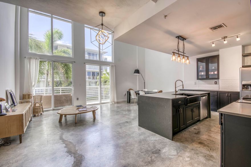 Experience coastal living at its finest in this stunning two-story loft just moments from the beach. Perfectly situated in a highly convenient location, this newer building offers modern design, comfort, and style all in one.  Step inside to discover soaring ceilings, an open-concept layout, and abundant natural light that enhances the spacious feel of the home. The loft has been thoughtfully upgraded with modern finishes throughout, including sleek flooring, contemporary fixtures, and a beautifully appointed kitchen. The second-floor loft space provides flexibility—ideal for a home office, guest area, or private retreat. Great for full-time residence, vacation getaway, or investment, this property delivers the perfect blend of modern convenience and lifestyle. AC is 2018. Imapct windows.