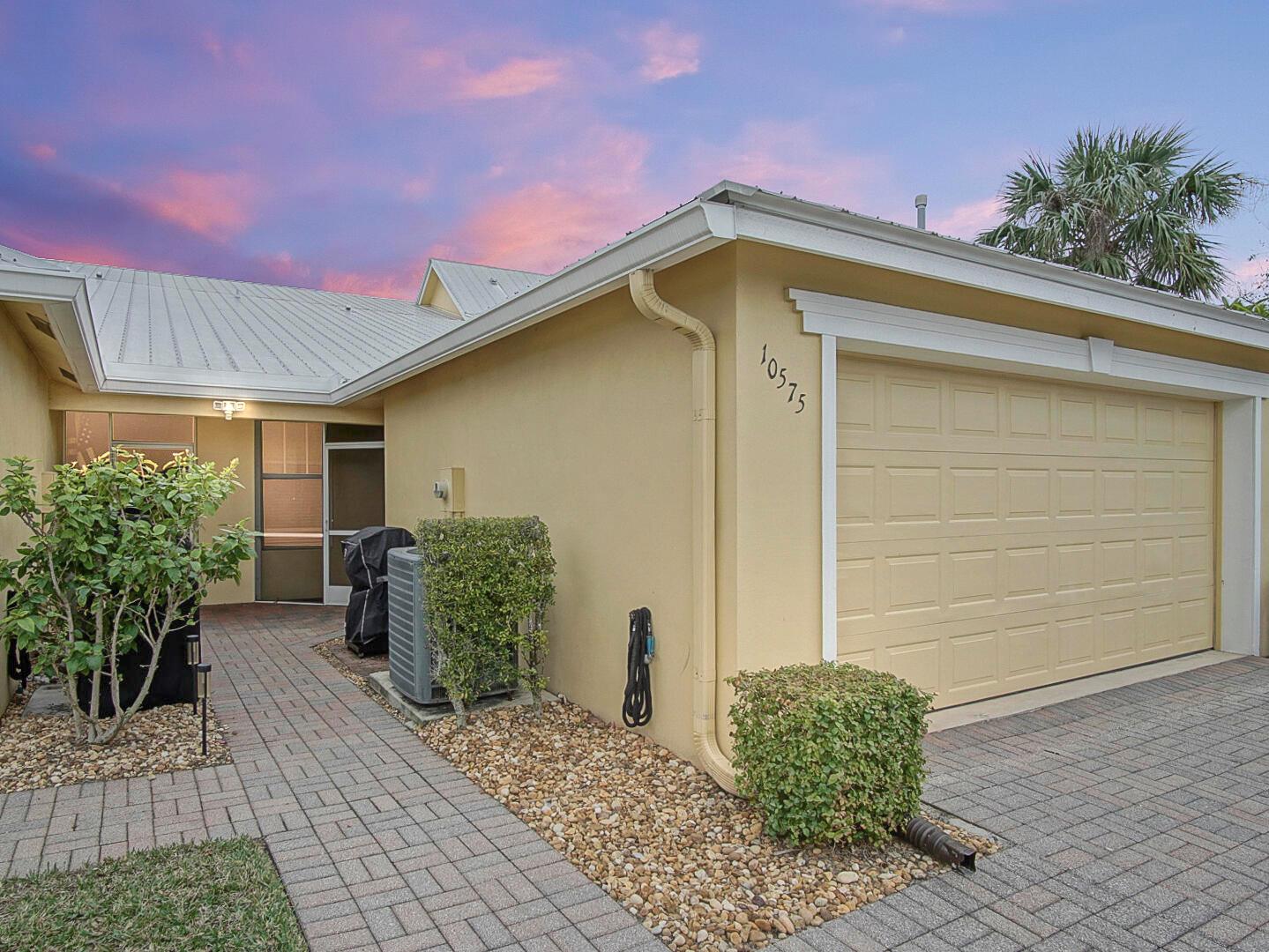 If you're looking for meticulously clean, close to loads of great amenities, and the most affordable way to own in Tradition, this is it! This one-level townhome is conveniently located directly across the street from a dog park, and a couple blocks away from the Bedford Park clubhouse with oversized community pool, a playground, a huge green area with beautfiul mature oak trees, and a serene butterfly park. Outside, you'll love the metal roof, gutters, and spacious two car garage. Step inside, and you'll appreciate the open, split-bedroom layout, tile flooring in the main, and gorgeous new LVT flooring in the bedrooms. Vaulted ceilings add to the space, and the kitchen is adorned with granite countertops, a stylish backsplack, matching stainless steel appliances, and an expansive pantry.