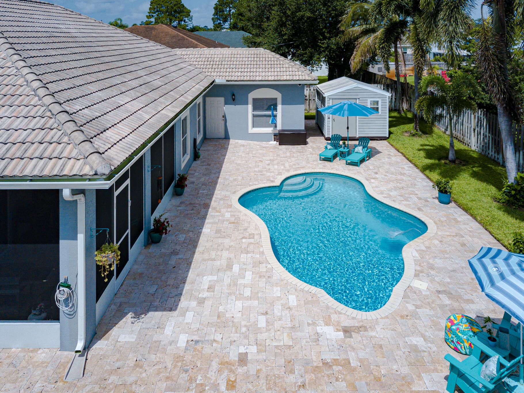 NO HOA! Spectacular Saltwater Pool Home on Oversized Corner Lot. Immaculately maintained 4/3/2, 2,403 sqft solid pour concrete home with circular driveway. Step inside to Italian Crema Marfil Marble floors flowing seamlessly through living areas, chef-inspired kitchen w/wall oven, new 36'' glass cooktop, new SS appliances. Plantation shutters. Master Suite is a true retreat, Brazilian hardwood floors, elegant tray ceiling, and slider to screened-in lanai. Enjoy dual walk-in closets w/built-ins, spa-like ensuite bath w/frameless corner shower, jetted soaking tub, dual vanities, private water closet w/toilet and bidet. Outside, unwind in your saltwater pool surrounded by a large, fenced backyard w/mature palms, fruit trees, and outdoor shower. Storage shed, used as a gym.