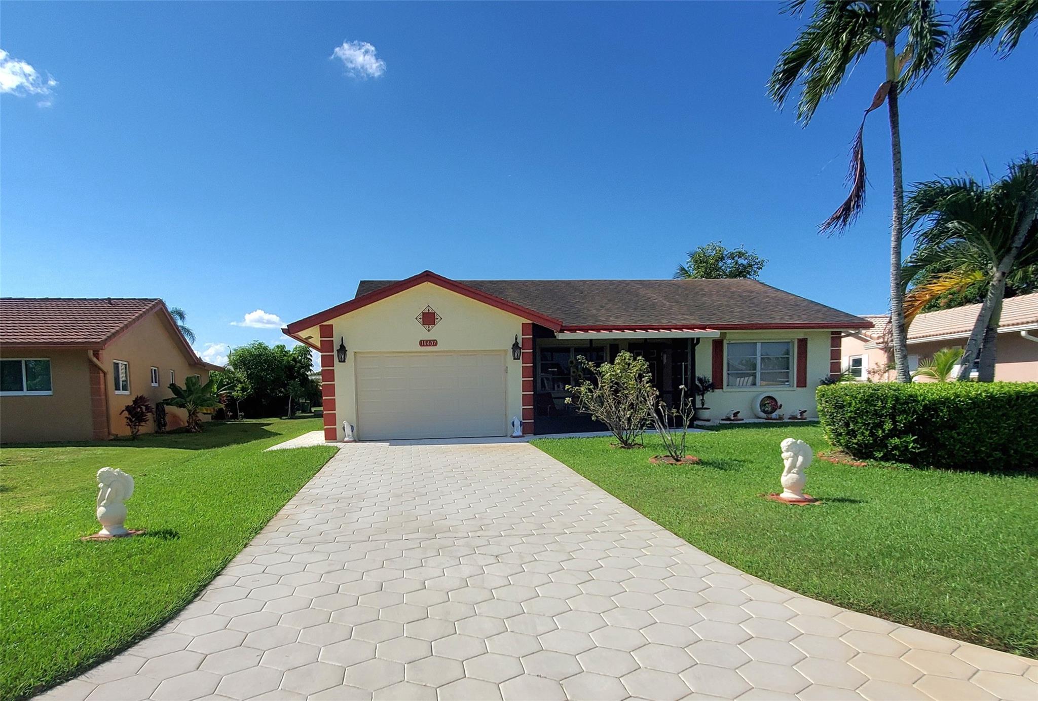 Welcome to this beautifully maintained 2-BDRM 2-BATH home with a 1-CAR GARAGE located in the sought-after community of "ISLES OF TAMARAC". The inviting foyer opens to a spacious open-concept floor plan featuring high ceilings in the Living & Dining RM. The home is fully tiled and boasts a remodeled kitchen (2022) with wood cabinetry, granite countertops, SS appliances & Breakfast nook. An elegant Bar area provides the perfect space for entertaining. The expansive primary suite offers a walk-in closet & direct access to a covered screened patio overlooking the lush garden. Additional highlights include a new electrical panel (2017), updated driveway & walkway (2023) & an epoxy coated garage floor (2023). Conveniently located across from the pool and clubhouse, this home is TRULY A MUST SEE!