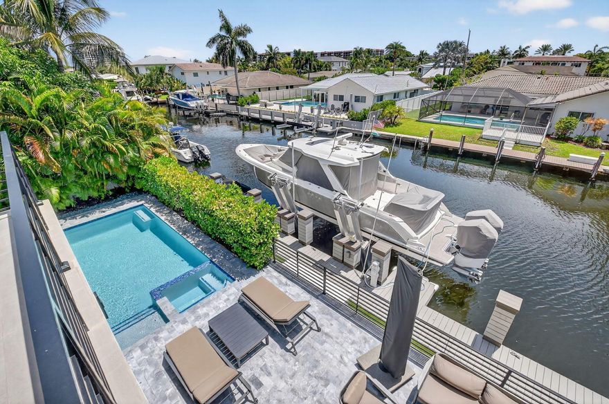 A true must see.  This stunning Contemporary Southern Exposure Home, nestled in the highly coveted Bel-Marra waterfront community, offers custom design finishes and unparalleled waterfront living -- a true paradise! From the moment you enter, you'll be captivated by the openness beauty of the Great Room, which sets the tone for the entire home.The open-concept floor plan boasts two bedrooms (one currently used as a game room with wet bar) and a full bath on the 1st floor. Step outside to discover an oasis with a saltwater-heated pool and spa, complemented by a fully equipped summer kitchen. The 80-foot dock, complete with a lift and additional twin jet-ski dock, ensures endless water activities and effortless access to the water.