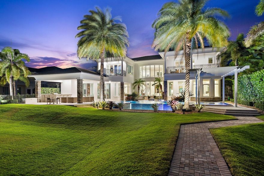 Located directly on the Intracoastal, across from the wide water opening to Loggerhead Marina - P.B.G., this amazing former model home has all the bells and whistles desired by the most discerning buyers.  Enter the grand foyer and experience two story volume with a wall of impact glass beyond the formal living room to the pool, grassy lawn, and 75' of waterfront dockage.  The master suite occupies the first floor, along with one guest suite, formal dining, den, wet bar, breakfast room, kitchen, laundry, and spacious family room with cabana bath.  The back yard boasts an amazing pool with spa, fit pits, rain trellis, and summer kitchen.  A private elevator or the grand staircase takes you to the 2nd floor with 4 guest suites, loft area, media room, and secondary laundry room Impact Glass throughout and  generator