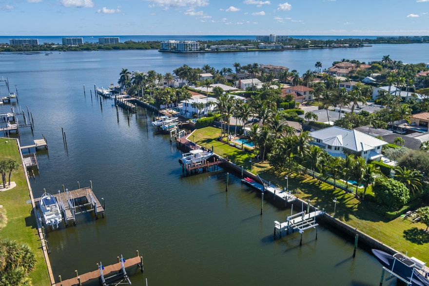 This stunning waterfront property in Lake Worth offers the perfect blend of luxury, privacy, and functionality. Situated at the end of a quiet cul-de-sac, the home boasts 125 feet of water frontage with a private dock, a 13,000-pound boat lift, and serene views from almost every room. Designed for both relaxation and entertaining, the property features a beautifully landscaped yard, a heated saltwater pool, and a covered outdoor loggia. Inside, the light and bright interior spans 4,546 square feet and is thoughtfully designed with seamless indoor-outdoor living in mind. The two-story foyer creates a grand first impression, leading to elegant living and dining rooms that open directly to the pool and waterfront. A large family room with a wet bar connects to the gourmet kitchen, which is