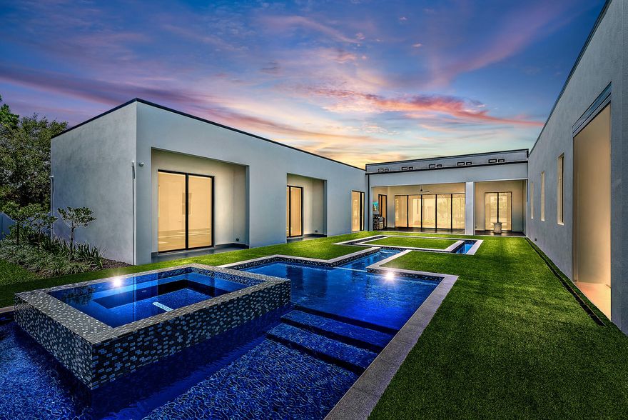 New Contemporary Home built in 2022 on over 4 acres of private Intracoastal property plus 2 acre lot next door. Perfect for the car collector or boater with 8 garages plus room for car lifts, and over a 100' of direct Intracoastal frontage. Sleek and clean lines, large floor to ceiling windows with long views of property and pool, 3 bedrooms in the main house and a detached guest suite with full bath and kitchen, theater, and office/exercise room.  Luxurious Owners Retreat with wood floors, fireplace, marble bath, dual sinks and water closets and a walk-in boutique style closet. State of the art contemporary kitchen with 2 wall ovens, wine wall, gas stove, push open refrigerators and freezer, butler's pantry & oversized walk-in pantry.