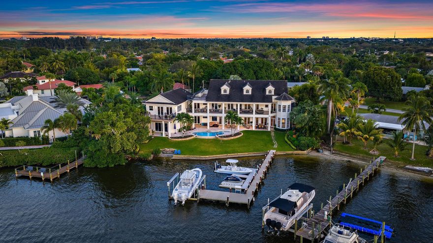 Discover this magnificent custom estate on the Loxahatchee River, featuring  stunning waterfront views and breathtaking sunsets. With 7,900 sq. ft. of luxurious living space across three levels, this home boasts 6 bedrooms, 7.1 baths, and a private guest suite, complete with an elevator for your convenience. Step into the grand foyer with a floating staircase, leading to elegant formal living and dining rooms, a gourmet kitchen with a butler's pantry, and a family room with a stylish bar. Enjoy leisure time in the billiard room or serene moments in the study/library. This estate showcases exceptional craftsmanship, including an exquisite remodel of the primary suite and bath, featuring an opulent custom dressing suite. The newly updated garage includes a gymnasium with water views,