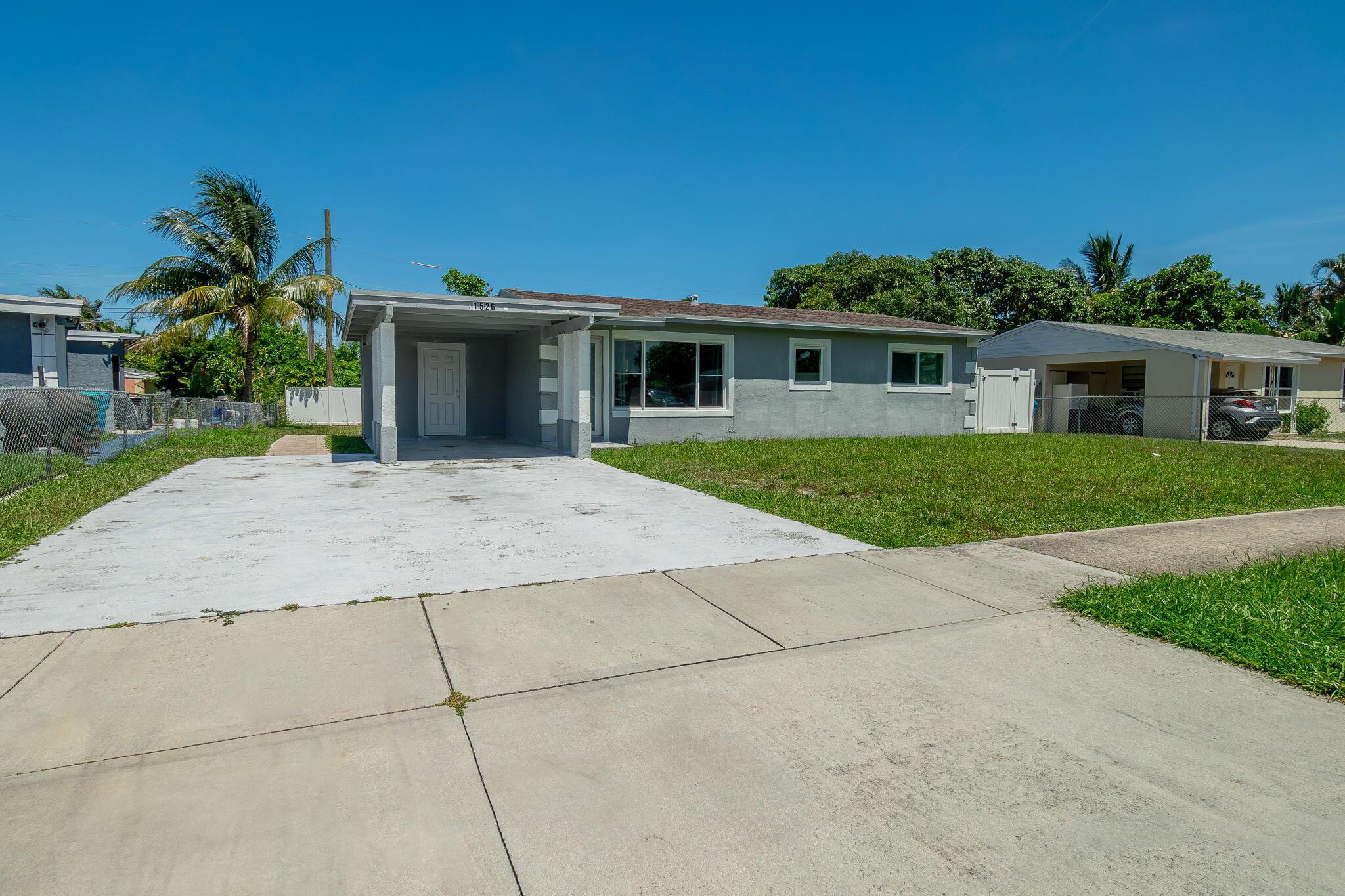 Available for rent in East Boynton, this single-family home features a spacious fenced-in yard, impacted windows and doors, three bedrooms, an updated kitchen and bathroom, and vinyl flooring throughout.
