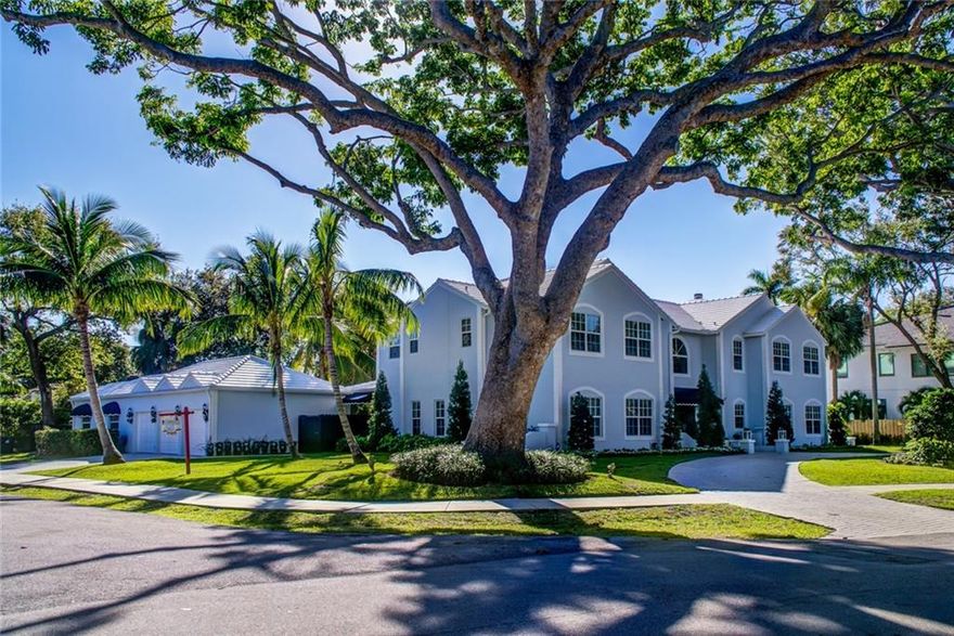 In the desirable neighborhood of Rio Vista lies this one of a kind over 1/2 acre "Coastal Themed Estate". Upon arrival in the circular driveway take note of the majestic African Mahogany Trees. Enter the home & the grand sweeping staircase meets you as does the volume ceiling w/ beautiful detailed wall & dental crown molding. A gorgeous formal living room with a wood burning fireplace & soaring ceilings, which flows through to the dining room & french doors to outside patio (all impact glass).