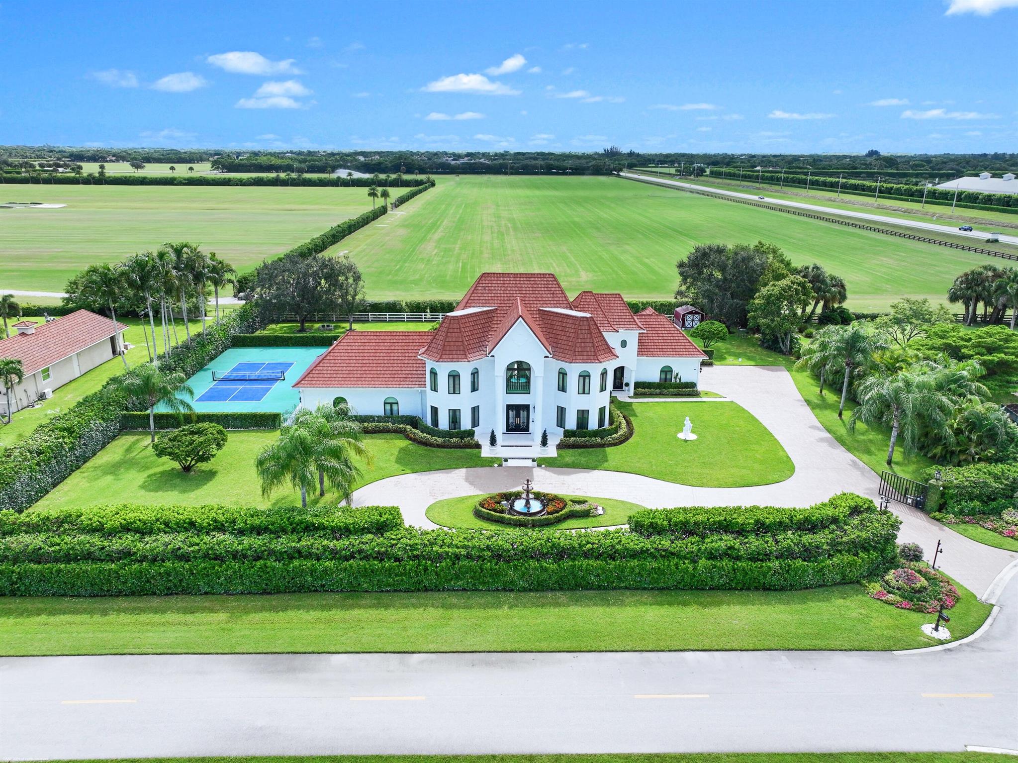 With no expenses spared, this completely renovated Southfield's of Palm Beach Polo Club Estate is situated on 5 private polo fields. One of best locations in town!  Appraised at $5.73M (June 2025), this turn-key 5 bed, 4.5 bath, 4,619 sq. ft. home is just a short golf cart ride from all equestrian show grounds. Enjoy this 5 Star resort style estate with stone coated metal roof, gated entry, heated 88ft long salt-water pool, pickleball court, and full outdoor kitchen. Stunning interiors with soaring ceilings, picture windows, spiral staircase, and chef's kitchen with 120'' marble waterfall island. Upgrades include new hurricane-proof windows/doors, 5 new remodeled baths, AC garage, Sonos audio, security cameras, water-leak detection, and whole-house generator