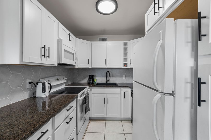 MOVE INTO THIS FURNISHED 2 BED 1.5 BATH CONDO ON THE SECOND FLOOR.  SUN FILLED, AIRY OPEN CONCEPT KITCHEN COMPLETE WITH GRANITE COUNTERS, PANTRY WITH PULL OUT DRAWERS,AND TILED BACKSPLASH. BRAND NEW HOT WATER HEATER ,UPDATED BATHROOMS NEW FAUCETS,PEDESTAL &WALL MOUNT VANITIES TILE FLOORS,CENTRAL AIR. BACK PORCH HAS LOVELY VIEW OF THE GARDEN & CANAL PLUS EXTRA STORAGE.STEPS TO THE DORCHESTER POOL ,5 MINUTE WALK TO THE HASTINGS FITNESS CENTER. WELL MANAGED ASSOCIATION. ROOF IS 2 YRS OLD , STRUCTURE GOOD RESERVES WORK HAS BEEN COMPLETE,AND HAS A PRIVATE SITTING AREA. LARGE WALK IN CLOSET, LAUNDRY ROOM ON THE SAME FLOOR, local bus for errands/shopping both within & outside The Village;.COME & ENJOY RESORT STYLE LIVING IN THIS GATED COMMUNITY FOR ACTIVE ADULTS 55 +. CLUBHOUSE features a theate CLUBHOUSE features a theater, indoor pool, card room, community/party room, billiard room ,shuffle board ,tennis , pickqleball ,bocce and two outdoor pools. Numerous heated outdoor pools throughout the community. Separate fitness center with gym , outdoor heated pool and a resistance pool. Two guarded gates and 24 hour roving security patrol. GREAT LOCATION: close to shops, restaurants, PBI airport and beaches.