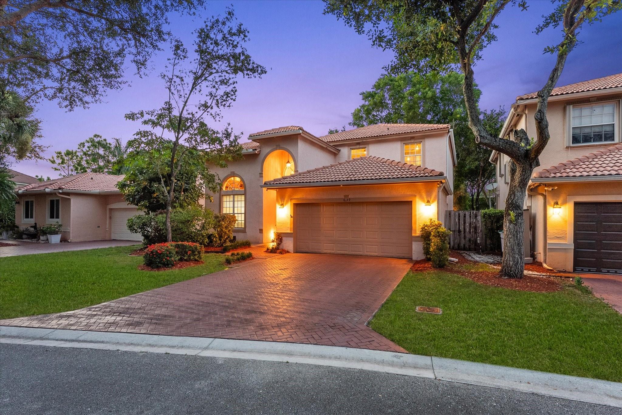 Tucked behind the gates of an intimate community & within a quiet cul-de-sac, this exceptional home offers incredible value & a serene setting to enjoy with family & friends. Inside, soaring ceilings, open living areas & expansive windows fill the space with natural light & provide picturesque views of the lush outdoor living areas, featuring tropical landscaping & a peaceful waterfall. The crisp white kitchen is spacious & boasts a large island, quartz counters & SS appliances. The flexible floor plan includes two lofts (one is the 5th Bedroom) with separate staircases—perfect for remote work, guests, or private retreats. Lawn care is included in the HOA fees, making life a little easier & more carefree. Walk, ride bikes to restaurants, shopping, parks etc. The beach is a short drive.