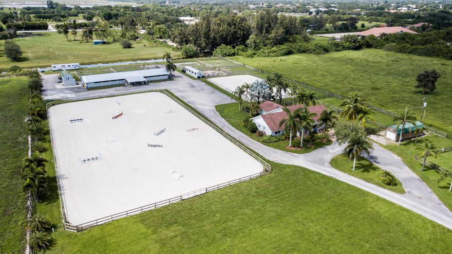 This Tranquil 5 Acre Wellington Equestrian Farm in the scenic neighborhood of Rustic Ranches is away from it all yet features close access to the horse show. 5 minute golf cart ride and 20 minute hack to WEF. Close access to the nature preserve with miles of impeccable horse trails. It is the 2nd farm directly off of Flying Cow.  Ability to put up Tent Stalls & accommodate RV's. This GEM of a farm features  2 barns totaling 20 stalls. The 16 stall center aisle barn is complete with fly spray system, 2 tack rooms, feed room, lounge with Washer and Dryer and full bath, The 4 stall barn is is complete with run-out paddocks. The 2 barns have 6 exterior wash stalls & 2 exterior grooming stalls on one side of barn and additional wash stalls & grooming stalls on other side making it convenient..