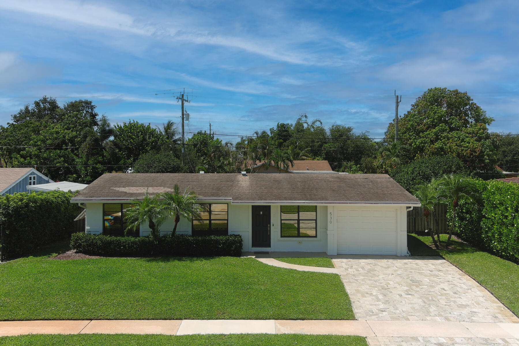 This stunningly remodeled 3br/2ba East Delray pool home truly has it all. Gorgeous wood grain porcelain tiles run throughout the home. The open, eat-in kitchen was completely reimagined with custom white shaker cabinetry, Calacutta quartz countertops and backsplash, high-end appliances, and designer hardware. The master suite boasts a separate sitting area and bath with fluted marble veined Italian porcelain tile, custom white shaker vanity with quartz countertop, and high-end polished chrome hardware. The spacious guest rooms enjoy walk-in closets and bountiful natural light. The stunning, oversized secondary bathroom includes a textured porcelain tile bath and custom wood shaker vanity with quartz countertops and chrome hardware. Additional whole-house upgrades include a new Nest