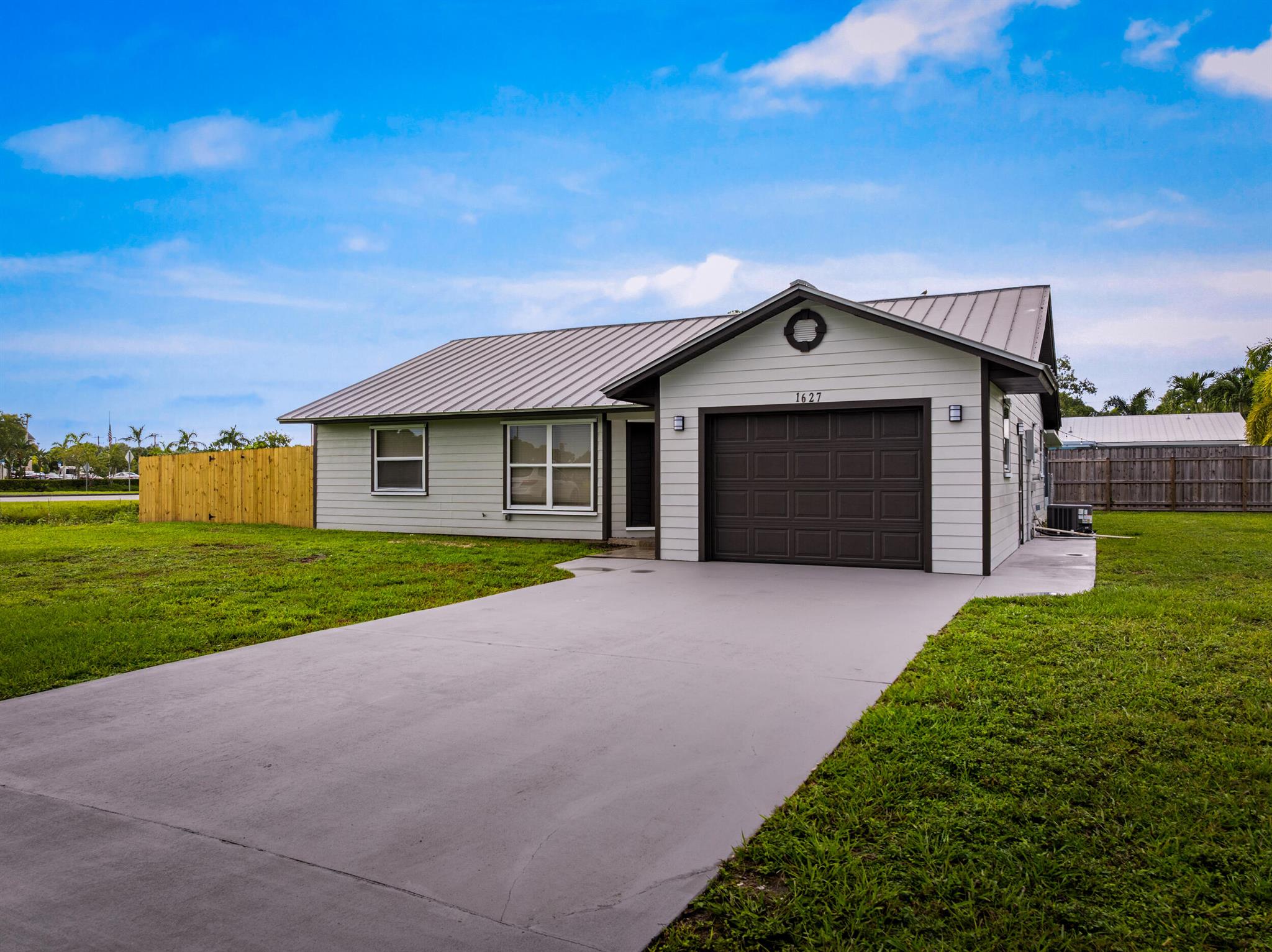 Welcome to 1627 SE Monroe Street in Stuart. This fully renovated 3-bedroom, 3-bath home sits on an oversized 11,151 sq ft corner lot in the sought-after Coral Gardens community. Recent updates include a brand-new A/C system, hot water heater, fresh paint, new flooring, epoxied garage floor and quartz countertops throughout. The kitchen shines with new stainless-steel appliances, white cabinetry, and a stylish backsplash, while each bathroom has been tastefully updated.Built for durability and curb appeal, the home features a metal roof and Hardi-Plank siding. An expansive 420 sq ft lanai provides the perfect outdoor retreat, and the large corner lot offers space for entertaining, gardening, or future enhancements. Located in a desirable Stuart neighborhood, 1627 SE Monroe Street blends