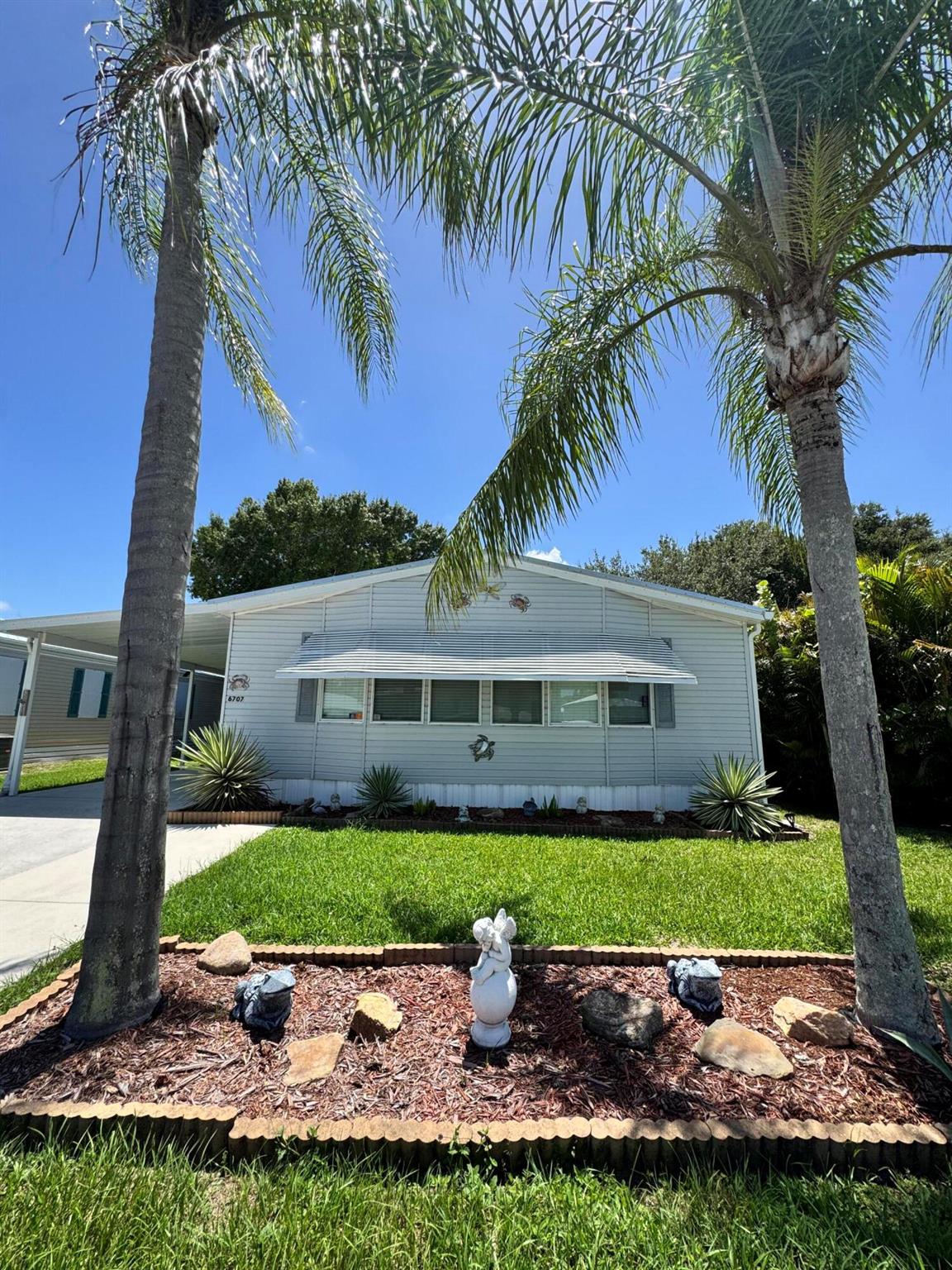Beautiful 2 bedroom 2 bath home in the desirable 55+community of Spanish Lakes Fairways. Built in wall shelves in Living room, family room as well as dining room.Flooring is laminate. NO CARPET. Small office space of family room. Open kitchen with island for added seating. Wonderful floor plan perfect for entertaining. Roof is 2024, A/C 2020. Dryer is 2020. Screened in lania perfect for morning coffee or evening cocktails. Very peaceful backyard with mature trees .Primary suite has double sinks with vanity, shower and separate tub. Lawn care and trash removal included in lot rent. 18 hole golf course included in lot rent. 2 pools, tennis, pickleball, bocce ball, shuffle board. club house and much more.Homes is turn key. Fully furnished so just bring your clothes!