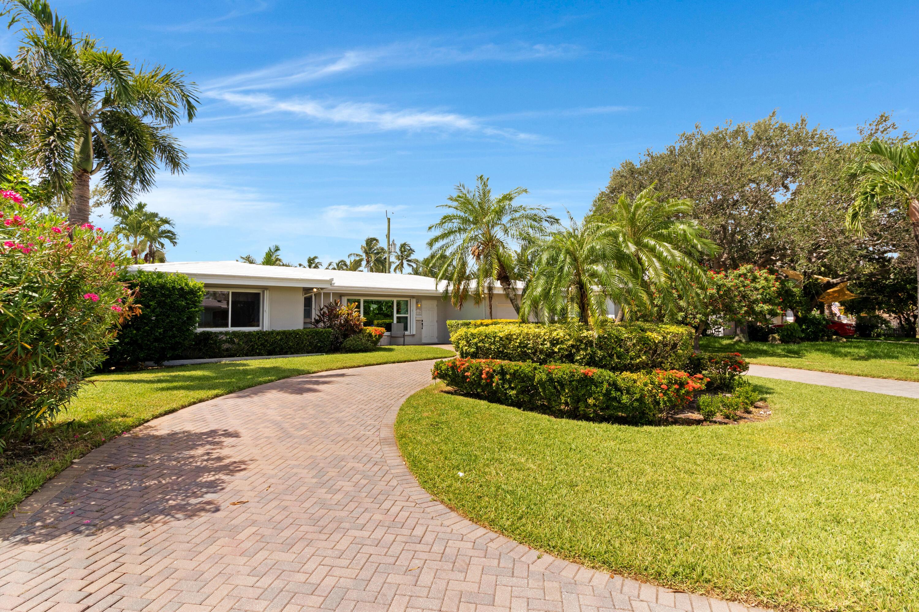 Live where others vacation in this primely located 2-bedroom, 2-bathroom home. EAST of Federal Highway and just half a mile from beautiful Pompano Beach! Inside, you'll find an airy open-concept floorplan that connects the living, dining, and kitchen--perfect for both entertaining and everyday living. The sun drenched Florida room offers peaceful views of the private pool, while a cozy fireplace adds unbeatable charm. Neutral tile flooring throughout, and elegant pendant lighting over the snack bar. The primary bedroom boasts custom closet built-ins and an en suite bath, while the second bedroom provides generous space and comfort. A sleek side-by-side washer and dryer are conveniently located in the garage. The lushly landscaped lot and circular driveway add practicality and...