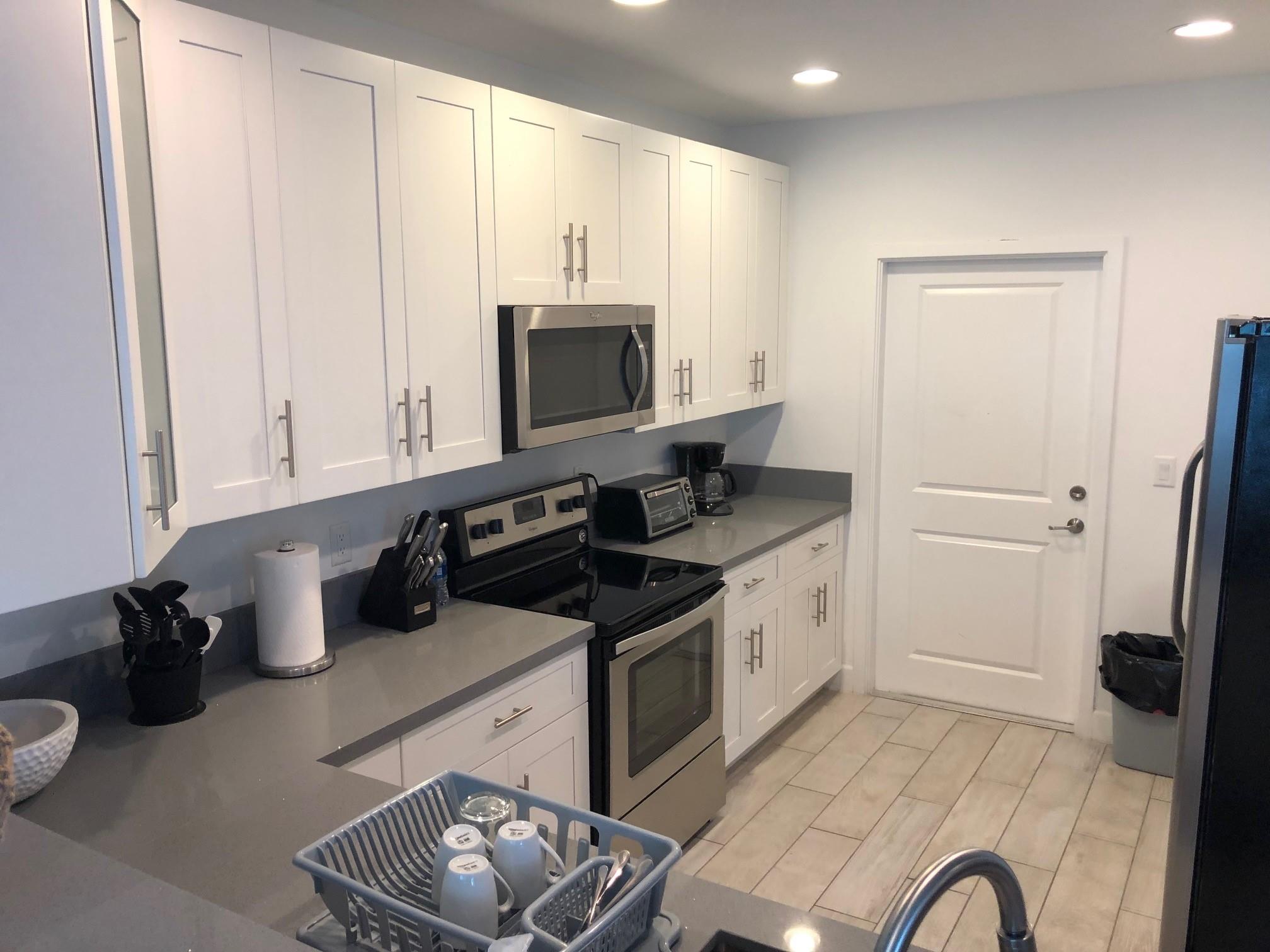 Newer construction corner unit luxury townhouse in River Oaks! Large open kitchen w/quartz counters,white cabinets & upgraded Whirlpool stainless steel appliances. Ample cabinets, counter space,pantry. Long breakfast/snack bar in kitchen that seats 4. Spacious dining room off kitchen with sliding door to patio. Living room also has a slider leading to back patio. Beautiful grey porcelain tile flooring throughout both levels w/carpet on the stairs only. 1/2 bathroom downstairs. Upstairs has 2 guest bedrooms & 2 guest bathrooms (one is en suite). Large master bedroom w/2 walk-in closets, dual sink/vanity in master and large walk-in shower. Volume (tall) ceilings on both levels. High impact windows & doors. 2 car garage,great location
