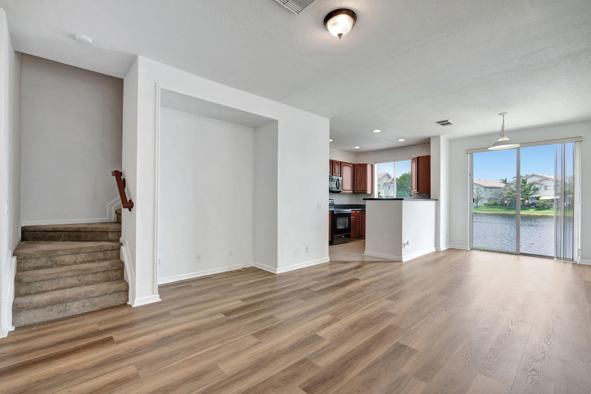 Welcome to the serene lakeside retreat of 3140 Laurel Ridge in the sought-after Thousand Oaks gated community of Riviera Beach, FL. This captivating 2-story townhouse boasts 2 generous bedrooms, 2 full bathrooms, and a convenient half bath, perfect for modern living. Spanning 1199 sq. ft. under air, this townhome provides ample space and comfort. Enjoy the ease of parking in your very own 1-car garage also offering an Electric Vehicle Charging Outlet 14-50. Step inside and be greeted by brand new premium vinyl flooring that adorns the first-floor living area, creating a warm and inviting ambiance. The upstairs is well-appointed with carpeting, creating a cozy and private haven for rest and relaxation.