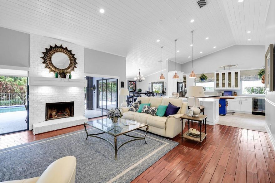 Located in sought-after Millpond in Boca Raton, this elegant home features wood floors, expansive windows, and sliding glass doors, filling the space with natural light. With a spacious open floor plan, shiplap cathedral ceilings, and a cozy fireplace, it offers 3 bedrooms downstairs (one primary)  and one bedroom upstairs (second primary) with a stunning loft/office/den with garden views. The masterful chef's kitchen boasts quartz countertops, stainless steel appliances, large pantry w lazy Susan, rolling island and custom window treatments. Outside, enjoy a private backyard with a large fenced in pool, lush landscaping, no rear neighbors and whole house solar panels. Close to Town Center Mall, top-rated private and public schools, beaches, parks and entertainment, Best location in Boca.