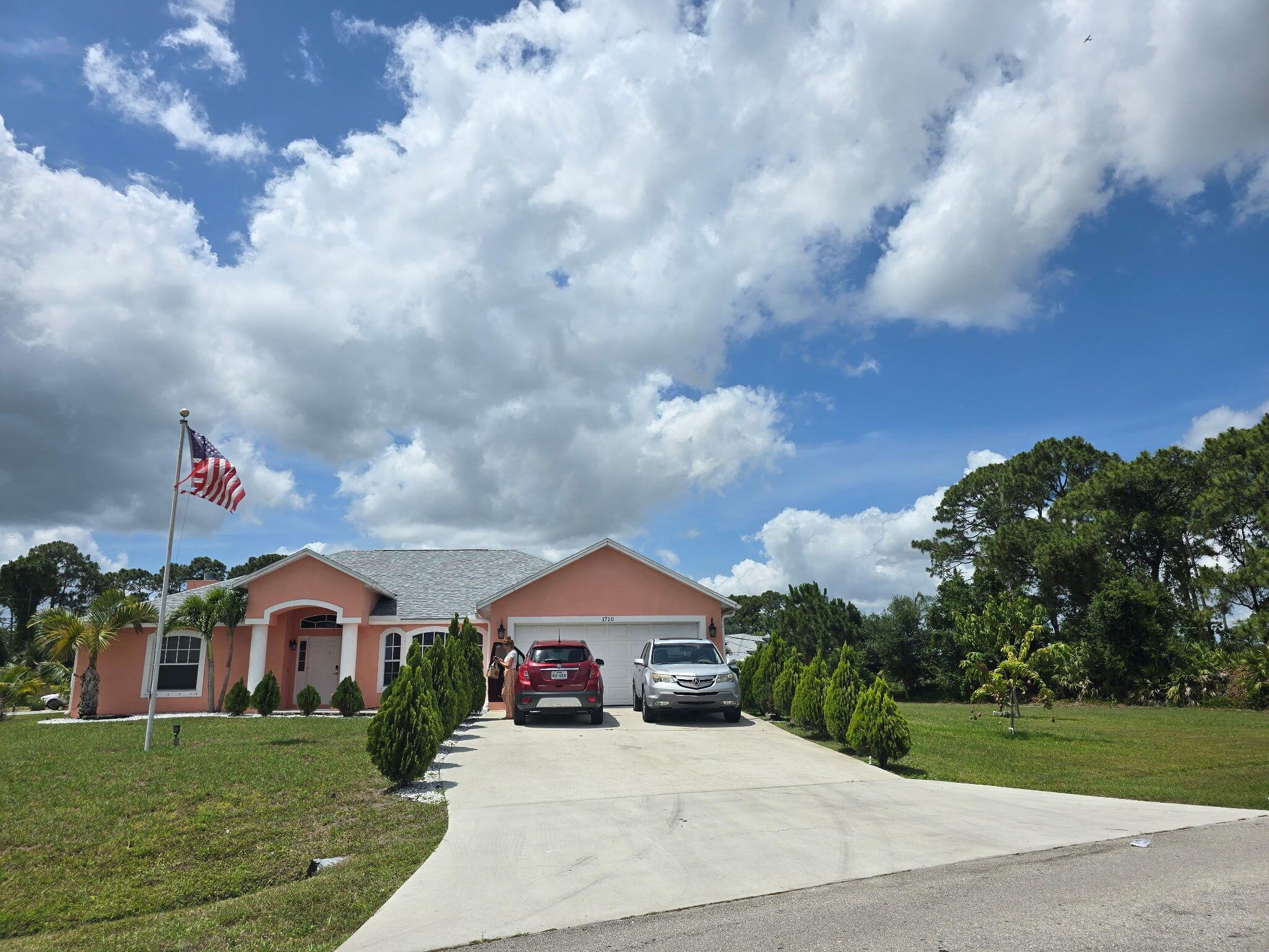 Completely updated interior and full of personality! This fabulous CBS home sits on a rare corner double lot in Port St. Lucie and offers 3 bedrooms, 2 bathrooms, a 2-car garage, and a spacious family room anchored by a beautiful wood-burning fireplace and built-in bar. Inside, you'll find vaulted ceilings, an open-concept kitchen with stainless steel appliances, granite countertops, and a tasteful tile backsplash. Tile floors run through the main living areas, while the bedrooms offer plush carpeting for comfort. The split-bedroom layout adds privacy, and the generously sized master suite features a walk-in closet, sliding glass doors to the patio, and a well-appointed bath with dual sinks, a soaking tub, and separate shower.