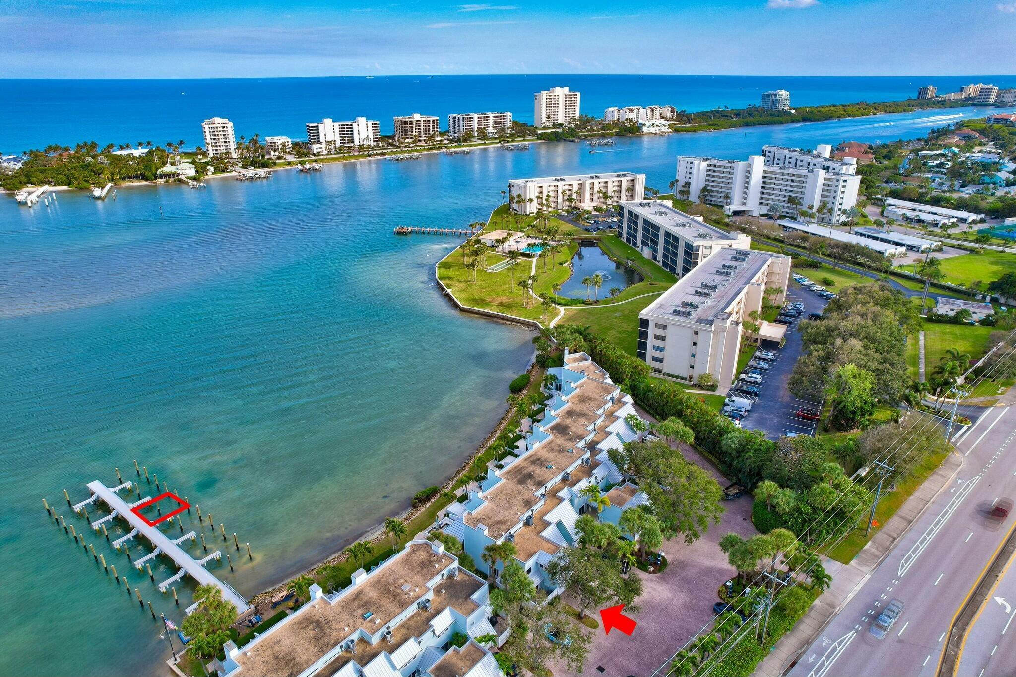 Experience the pristine blue waters of the Intracoastal with breathtaking views of Jupiter Island. Just minutes from the ocean via the Jupiter Inlet, Scrimshaw on the Bay offers a private oasis of only 21 Key West-style townhomes along the shoreline. This coveted 3-bedroom end unit boasts expansive, panoramic views and was fully renovated in 2024. The property features a brand-new boat dock and an extended patio with elegant pavers and landscape designed by Bloom Landscape. The garage is finished with durable epoxy-coated floors. Inside, the kitchen stands out with Italian porcelain flooring, custom solid wood Bremtown cabinetry with EuroSlab soft-close design, Cambria Clifton quartz countertops with a waterfall edge, and LED under-cabinet lighting. Top-of-the-line LG stainless steel