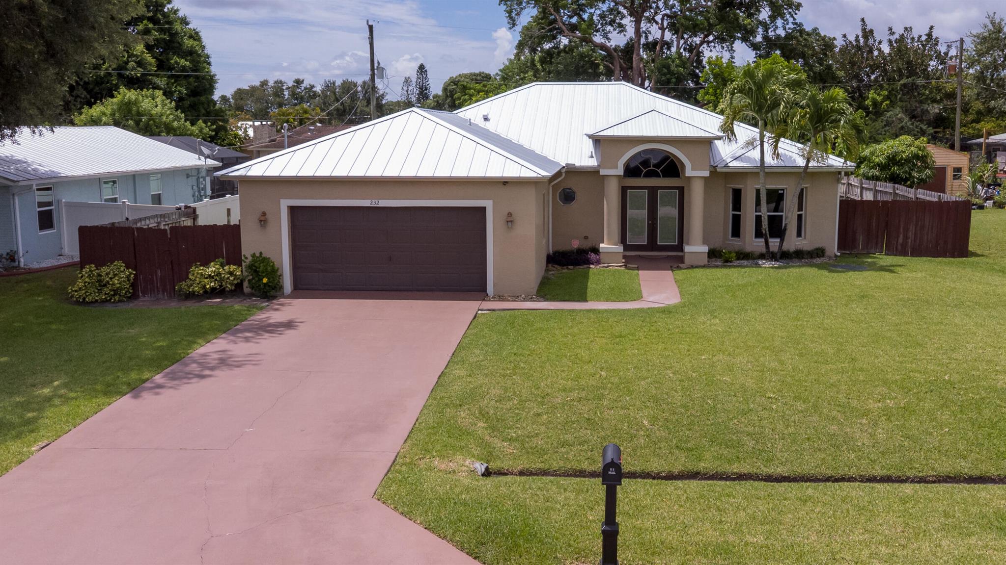 This stunning home is nestled on a spacious lot in a prime location, offering the perfect blend of comfort and style. With a metal roof (2025) and an HVAC system (2020), this home is built to last. The backyard features mango trees, perfect for enjoying fresh fruit in your fully fenced oasis. Inside, you'll find 3 generously sized bedrooms, 2.5 sleek bathrooms, and a spacious open-concept kitchen and family room. The bonus den offers endless possibilities -- use it as a formal dining area, convert it to a 4th bedroom, or create your dream home office. Additional highlights include a huge driveway that fits 4+ cars, a two-car garage, vaulted ceilings, mostly tile floors throughout, granite countertops, and a beautiful decorative fireplace. This amazing home is waiting for you!