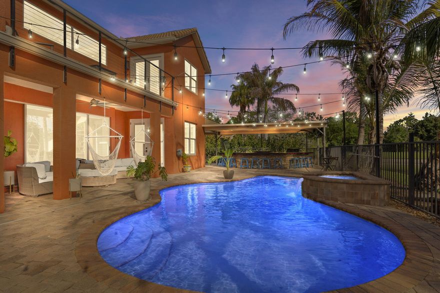 Welcome to an exceptional lakefront retreat offering the perfect blend of luxury, space, and lifestyle. This stunning 6 bedroom, 4 bath residence features soaring ceilings and a light-filled, open design that creates a grand yet inviting feel throughout. The beautifully updated kitchen serves as the heart of the home, showcasing modern finishes and flowing seamlessly into the main living areas ideal for both everyday living and effortless entertaining.  Step outside to your own private resort-style oasis. A sparkling pool and relaxing hot tub overlook tranquil lake views, while the expansive outdoor summer kitchen creates the perfect setting for hosting, dining under the open sky, and enjoying unforgettable sunset evenings. This outdoor space truly defines the Florida lifestyle. The home continues to impress with a private movie theater and generously sized bedrooms, offering both comfort and versatility for family and guests. The luxurious primary suite features a fully updated master bathroom complete with a freestanding soaking tub and a massive glass enclosed shower, delivering a true spa-like experience.  Additional upgrades include a new A/C system and impact windows for year-round comfort and peace of mind. Ideally located just minutes from I-95, downtown Stuart, and the area's pristine beaches, this home offers the perfect combination of elegance, convenience, and coastal living.