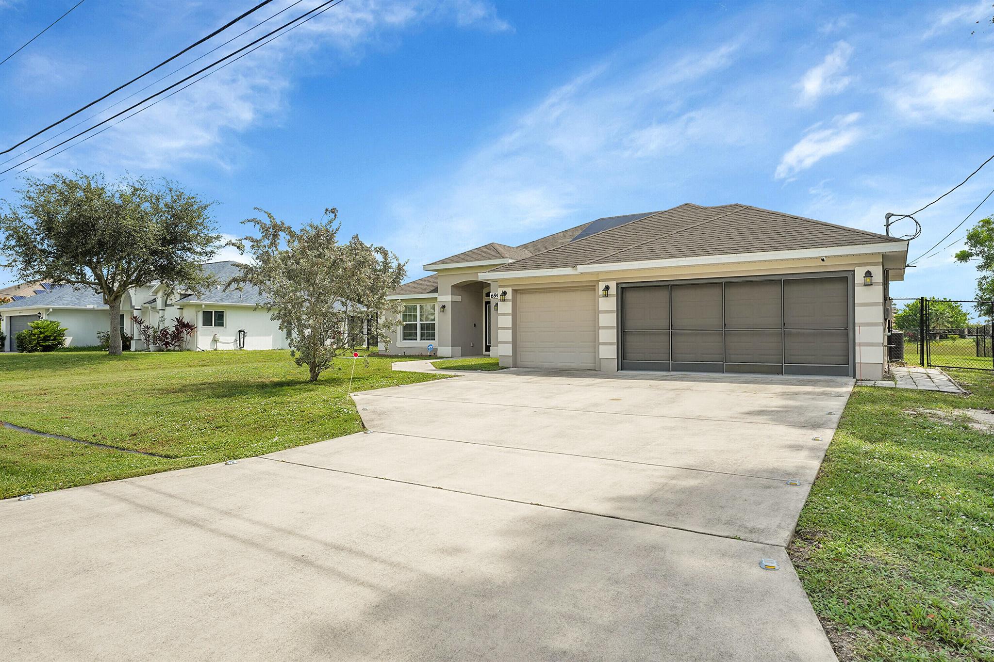 Built in 2018, this 4BR/3BA CBS home offers 2,266 sq ft with a 3‑car garage on a quarter‑acre lot backing a peaceful reservoir. The split plan features a granite kitchen with stainless appliances and breakfast bar, open living/dining, and a spacious primary suite with dual vanities, soaking tub, and walk‑in shower. Benefit from a low cost electric bill with a paid off solar system! Enjoy sunsets from the screened lanai and a fully fenced yard. Minutes to PGA Golf, River Park Marina, shopping, dining, and Hutchinson Island beaches, with easy access to I‑95 and the Turnpike.