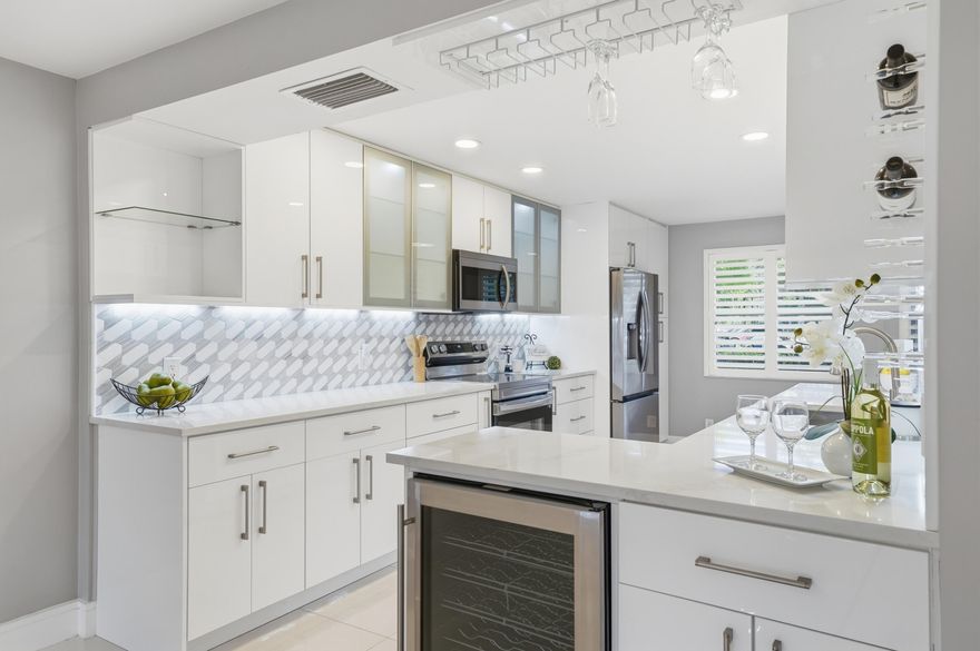 Step into luxury with this fully remodeled 1st-floor 2BR/2BA condo in Wynmoor; a premier 55+ active community. Everything is NEW! 2025 A/C, 2024 stainless steel appliances, impact windows with plantation shutters and sleek tile flooring throughout. The designer kitchen boasts quartz countertops and custom lighting. Enjoy serene lake views from your living room, enclosed patio or spacious primary suite. Oversized walk-in shower, dual sinks, & custom closet. Full-size washer/dryer in unit. Parking right outside your door. Resort-style amenities include golf, pools, fitness center, pickleball, billiard hall, theater, dining, ballroom, classes, activities, tennis, walking trails & BBQ area. On site maintenance staff, transportation and 24/7 gated security. Turn-key living in Coconut Creek!