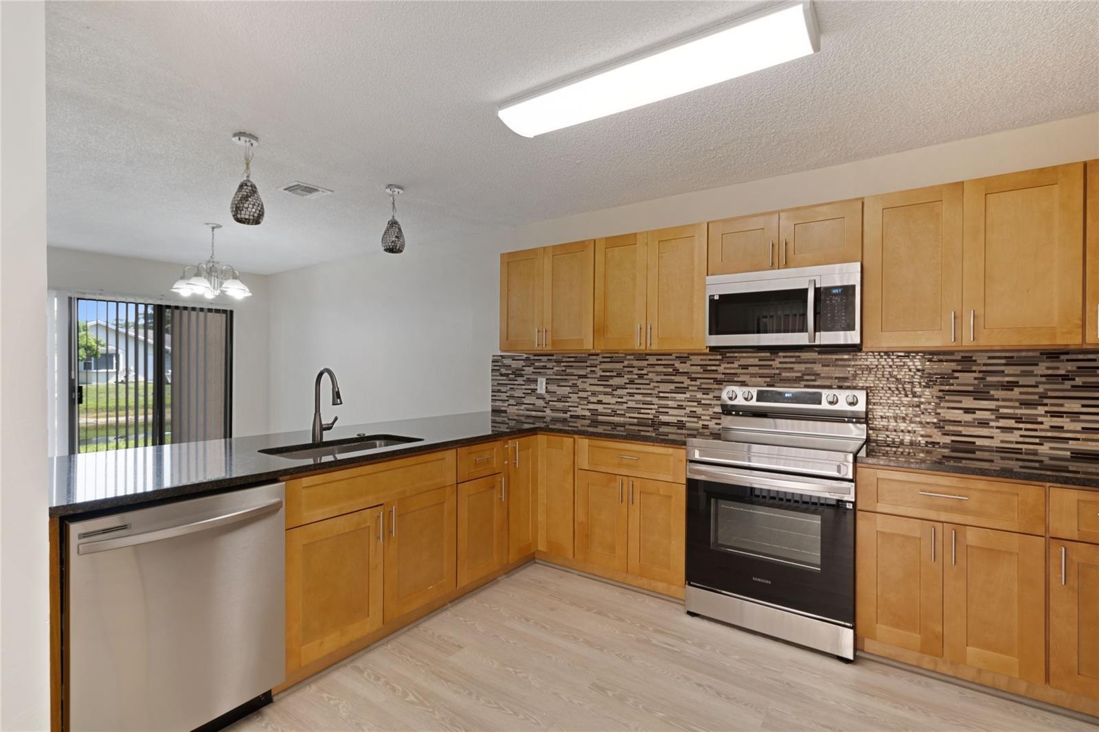 Property may qualify for City of Tamarac First-Time Homebuyer down payment assistance program. Buyers are encouraged to visit the city's official website for eligibility details and application requirements. No expense spared! step into this beautifully remodeled 3-bedroom, 2.5-bathroom townhouse located in the highly desirable community of pineapple park at Woodmont. Featuring a serene water view, brand-new high-end flooring throughout. this home boasts a spacious open floor plan filled with abundant natural light. Enjoy a modern kitchen with granite countertops and new stainless-steel appliances, perfect for entertaining. The updated bathrooms offer sleek finishes, and the new in-unit washer and dryer add convenience. Located in a pet-friendly community.