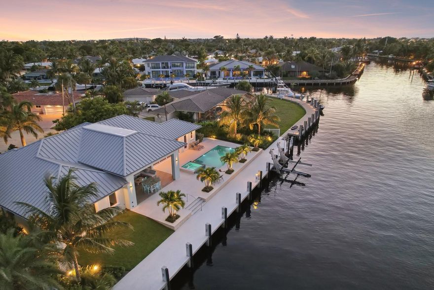 Another exquisite 2021 custom-built home by Z Construction & Remodeling! This unique lot offers 134 FT of unrestricted saltwater access located on 2 wide turning basins, allowing for (approx. 7FT at mean low tide) for your yacht & 20K lift for your center console+room for your toys. Sloped travertine access point to your 124FT concrete dock w/100AMPS power + water. A new seawall (pool & home built on pilings) is from scratch. Enjoy true Florida living with w/meticulously designed indoor & outdoor spaces that become one, creating the perfect ambiance. 13Ft. coffered ceilings w/woodwork details inside & carry outside to a full living area & kitchen, adding 507Sq. (3157SQ) Custom-designed kitchen & baths with timeless class! Close to both Inlets. 1-mile to The Cove, beach access & fun!