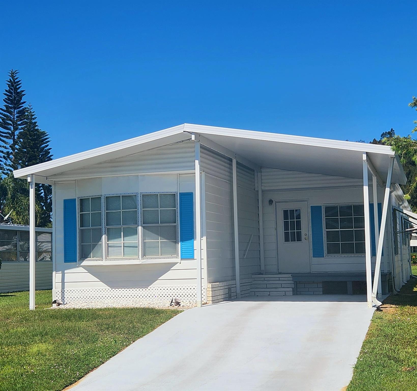 Charming, well kept home is move in ready! Meticulous cleaned & well maintained, this home has over 1300 sqft w/ 2 Bed/2 Bath. Split bedrooms, large Florida room perfect for a home office, 2nd living room, pet or plant room! You will be pleased w/ this prime location; close to the beach, mall, grocery stores, shopping, post office, banks, hospitals & more. Lot lease includes 865.27 security, cafe, Clubhouse w/activities, lawn care, trash, free private golf course, bingo, heated pool, pickleball, tennis, workshop, shuffleboard, bocce, gym, library, cards, Mahjong, clubs & more! Grab your slice of paradise in the highly desired town of Port St Lucie!