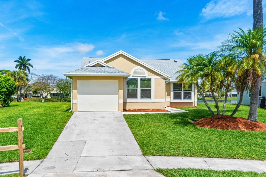 Welcome home to this beautifully maintained lakefront property in one of Boynton Beach's most sought-after neighborhoods. This three-bedroom, two-bathroom single-family home with a split floor plan offers the ideal combination of modern updates, comfortable living, and serene waterfront views on a generously sized lot.  Natural light pours through brand new double-pane low-E windows, creating a bright and inviting atmosphere in every room. Tile flooring runs throughout the common areas, providing a clean and cohesive look. The kitchen features new appliances, a new sink, garbage disposal, and soft-close cabinetry, making it both functional and stylish. Both bathrooms have been thoughtfully updated, and every outlet and switch in the home has been replaced. All popcorn ceiling texture   has been removed, giving the interior a fresh, modern finish.  The primary bedroom includes dual closets for generous storage. Step outside to the spacious ten-by-seventeen screened patio overlooking the lake, a perfect retreat for morning coffee or quiet evenings. The roof was replaced in 2022, and new ductwork ensures efficient climate control throughout. A zoned automatic sprinkler system keeps the landscaping green and healthy, while fresh paint inside and out ties the entire package together. The garage is equipped with a new door opener, adding one more layer of convenience.  The surrounding neighborhood offers excellent access to everyday essentials and recreation. Publix is just minutes away for groceries, Melear Park provides nearby outdoor activities, and the Boynton Beach train station offers convenient transit options. Beach enthusiasts will appreciate the short drive to the Boynton Beach Inlet.  Homes like this, with lakefront views and this level of updates at this price point, do not last long. Schedule your private showing today before someone else makes it theirs.