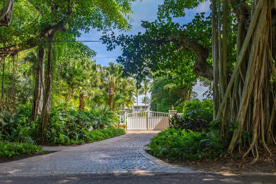The banyan tunnel leads you to a rare trophy WATERFRONT estate, move-in ready and fully furnished. At the end of Stuart's most photographed road, your gated drive opens to nearly an acre of PRIVACY and 500' of protected shoreline with sweeping views toward the INLET and ''The Crossroads.'' Enjoy true deepwater dockage with multiple docks, two lifts, room for an 80' yacht, and quick ocean access. Reimagined in 2023/2024 with a new standing-seam metal roof, full impact glass, whole-house generator, and new garage doors. The home blends timeless Key West architecture with modern coastal design. Perfect for true boaters and entertainers, with media room, balcony suite, heated saltwater pool, tiki bar, lush landscaping, guest house, no HOA, minutes from downtown Stuart, and not in a flood zone