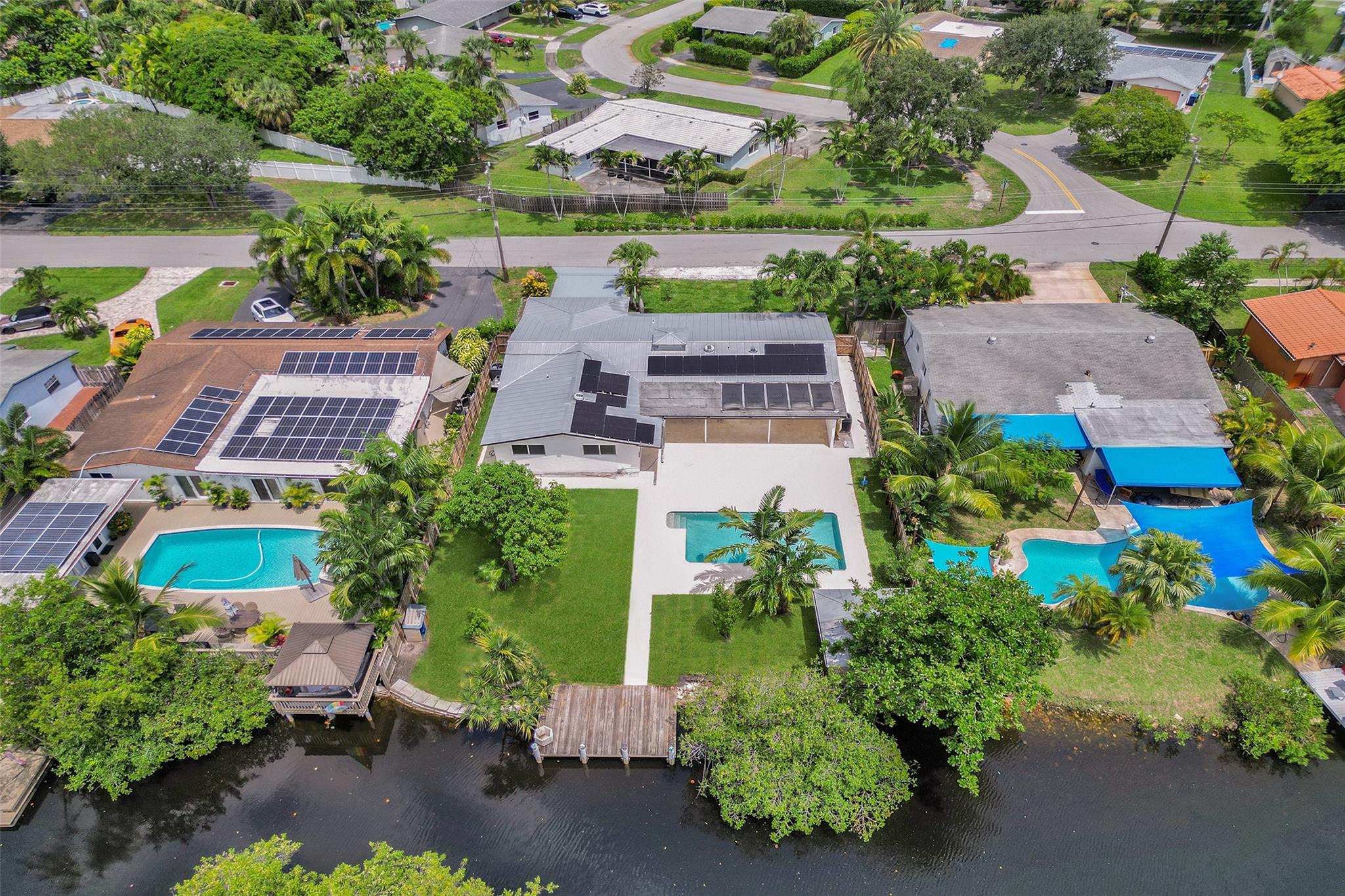 For those seeking a luxuriously remodeled, contemporary home w/ ocean access & extensive upgrades, look no further—this is your private paradise! Striking stacked-stone façade w/ 2002 metal roof & energy-efficient 2024 solar panels. Inside, the open-concept kitchen showcases shaker cabinetry, quartz counters, waterfall-edge bar & premium appliances accented in gold. Split BR layout ensures privacy, while spa-inspired baths create a resort-like atmosphere. Elegant porcelain tile flows thru/out, supported by a 2-zone AC system (2020/2022). Step outside to your oversized backyard designed for entertaining, featuring Jerusalem stone patio, sparkling pool, tiki hut & private dock. 2-car garage, sep. laundry, upgraded lighting, fans & more add to this exceptional property...a true must-see!