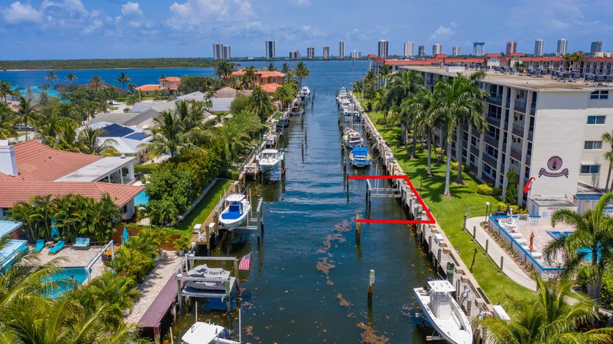 65' DOCK INCLUDED!! NO FIXED BRIDGES!! ATTENTION BOATERS!!! SIXTY FIVE CONTIGUOUS FEET OF DOCKAGE, consisting of 2 slips (30' & 35'), one with a 12,000 pound lift. Use one and sell the other or bring the BIG BOAT!! Dock fees are $200 PER YEAR! Offering the best of South Florida living, this 2 bedroom, 2 bath ground floor condo is just steps from the pool, grill & dock and faces the beautiful multi million dollar homes across the canal. Additional features include a screened patio, tile throughout, fresh paint, partial impact windows and the most sought after parking space. If world class fishing and boating isn't enough, the amazing NPB location offers the best restaurants, shopping, beaches, parks and golf courses. Don't miss this opportunity.  65 feet doesn't come around often
