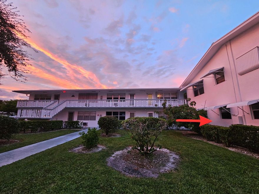 Step into this inviting first-floor corner condo and immediately feel at home. Designed for comfort and convenience, this residence features central AC. The open layout highlights sleek ceramic tile flooring, tastefully updated bathrooms, new lighting in the dining area and a new ceiling fan. Enjoy tranquil Florida evenings from your spacious patio. Community laundry and mail rooms are conveniently located just steps from your door.  Outside, discover an active 55+ lifestyle with 24-hour manned security, a courtesy bus, and endless amenities including a clubhouse, fitness center, indoor and outdoor pools, tennis and pickleball courts, shuffleboard, sauna, and a movie theater. Perfectly situated near the Okeechobee Blvd gate, you'll find shops and restaurants plus quick access the turnpike.