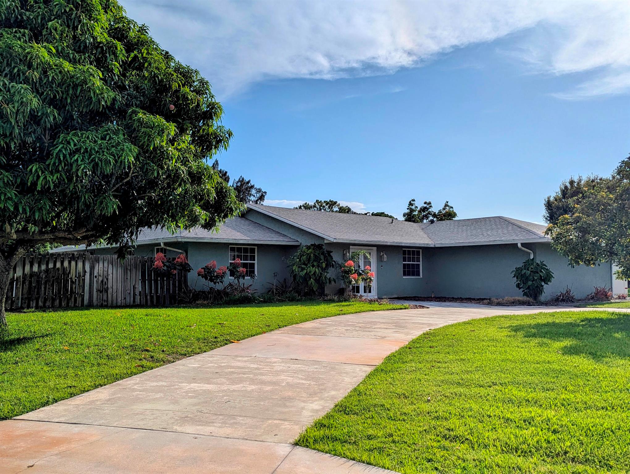 Enjoy Country Living just minutes from all the conveniences! This spacious 3 BR plus den/office, 2 bath, 2 CG home with screen enclosed pool sits on a full half acre corner lot. All impact windows and whole house generator! 2021 Roof! 2019 AC and HWH! Park your boat behind the privacy fence, and be on the water in minutes. Long circular drive and side drive offer ample parking for entertaining. Vaulted ceiling, tile and hardwood laminate floors, updated kitchen and baths, huge patio and screened pool area, large free form pool, storage shed, fruit trees, so much to love! No mandatory HOA fees! Minutes to Jensen Beach, Stuart, Port St Lucie, beaches, shopping, dining, entertainment. See attached list of improvements.