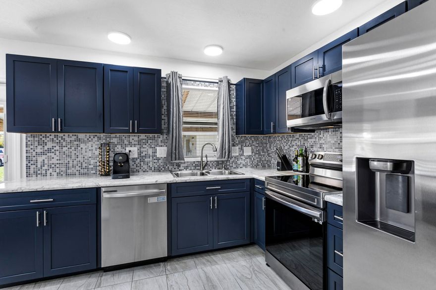 Welcome to your beautifully remodeled home.  This fully renovated home has been thoughtfully updated from top to bottom with meticulous attention to detail. The kitchen features striking Blue soft close cabinets, brand-new stainless steel appliances, new countertops, updated lighting and fixtures, and a convenient breakfast bar. Luxury vinyl flooring runs throughout the home, and every room has been freshly painted. New light fixtures and ceiling fans add a modern touch.  The spacious living room is filled with natural light and opens to a screened-in patio with tile flooring, an ideal space for relaxing or entertaining. New French doors lead the way outside. The main bedroom includes a generous walk-in closet, while the en-suite bathroom offers dual sinks and a step-in shower.  Everything is brand new, including the vanity, toilet, shower, and lighting. The guest bedroom is also roomy with its own walk in closet, and the guest bathroom has been completely updated with a new tub shower combo. Additional conveniences include an indoor washer and dryer, ample storage throughout, an expanded storage shed, and designated golf cart parking, golf cart included. There is truly nothing left to do but move in.  Located in a desirable 55+ gated community, residents enjoy heated pools, pickleball courts, bocce ball, shuffleboard, and an active clubhouse offering cards, bingo, games, dances, potlucks, and more. The community is just minutes from beautiful beaches, shopping, and dining.  Don't miss the opportunity to make this lovely home yours.