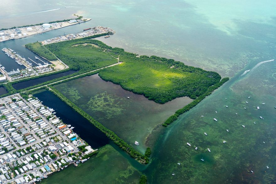 Nestled along the serene waterfront, these two picturesque parcels offer an unparalleled opportunity to indulge in the quintessential Florida Keys lifestyle. Boasting breathtaking panoramic views of the glistening waters, these two expansive plots of land / bay bottom present the perfect canvas for your dream waterfront retreat and /or commercial ventures. The Northern parcel consists of about 1,400 ft. of pristine shoreline, providing ample space for waterfront activities such as swimming, fishing, kayaking, and paddleboarding with deep water on one side and shallow bay bottom on the other side. Spanning 2.03 acres of Mixed Use upland and a total of 45 acres, including bay bottom. Potential uses on the Northern parcel could be Commercial retail, restaurant uses, or any combination there thereof, imagine a floating restaurant, small marina, Commercial recreation uses including amusement or sea life park, opening doors to community-centric projects that serve the needs of locals and visitors alike. The off shore island along the channel offers great camp sites. With Mixed Use zoning in place, commercial fishing docks are permitted, providing an excellent opportunity for entrepreneurs in the fishing industry to establish a thriving business. The Southern parcel consists of 50 acres of mangrove forest, beach berms, hammocks, and trails with approx. 6 acres of upland. So many possibilities. Build your own Equestrian Estate, ''The Southernmost stables''. This property would be an excellent place to host large events like concerts, weddings, farm to table / wine tastings, or possibly therapeutic programs or retreats. Beautiful beach areas. Easy to get to, as the island has access to the mainland via a ½ mile land bridge. The property is also located next to one of the largest mega yacht marinas and close to two upscale hotels. The Southern parcel of Cow Key can be purchased by itself. See MLS RX-10804772.