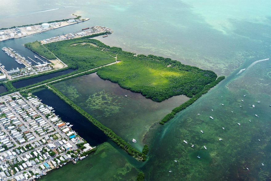 Nestled along the serene waterfront, these two picturesque parcels offer an unparalleled opportunity to indulge in the quintessential Florida Keys lifestyle. Boasting breathtaking panoramic views of the glistening waters, these two expansive plots of land / bay bottom present the perfect canvas for your dream waterfront retreat and /or commercial ventures. The Northern parcel consists of about 1,400 ft. of pristine shoreline, providing ample space for waterfront activities such as swimming, fishing, kayaking, and paddleboarding with deep water on one side and shallow bay bottom on the other side. Spanning 2.03 acres of Mixed Use upland and a total of 45 acres, including bay bottom. Potential uses on the Northern parcel could be Commercial retail, restaurant uses, or any combination there