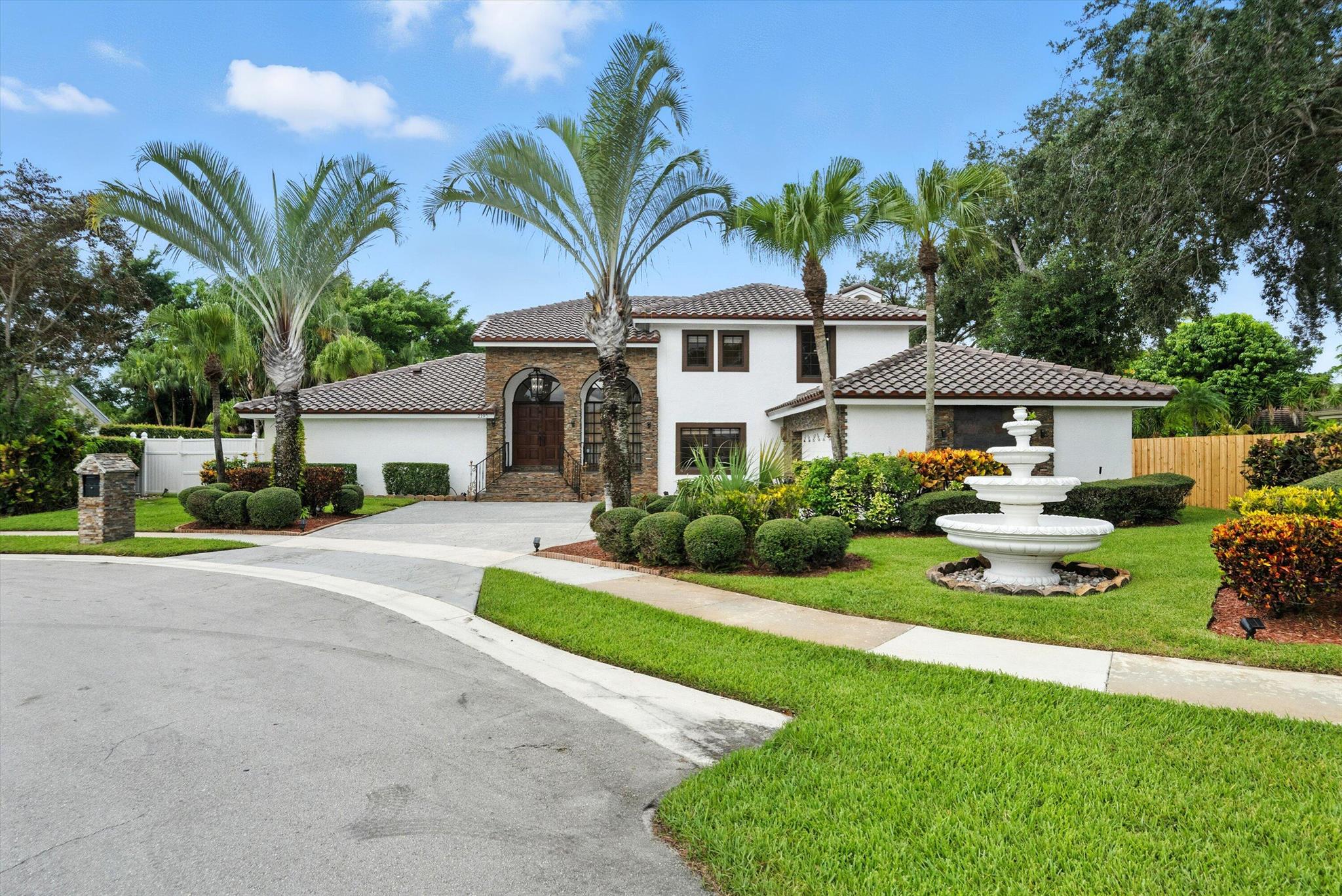 Welcome to this Mediterranean-style retreat in the heart of Wellington, FL, perfectly situated on a quiet cul-de-sac with sweeping waterfront views and a private oversized boat dock. Offering 2,403 square feet of light-filled living space, this beautifully maintained home is designed for both everyday comfort and memorable entertaining. Step through the impressive wooden entry doors into a warm and inviting interior, featuring a cozy living room fireplace. The primary suite is conveniently located on the ground floor, while two additional bedrooms, a loft and bathroom upstairs provide space for family or guests. A versatile office/flex room on the main level adds to the functionality of this home. Recent upgrades include a new clay tile roof and a newly resurfaced, heated pool. The outdoo