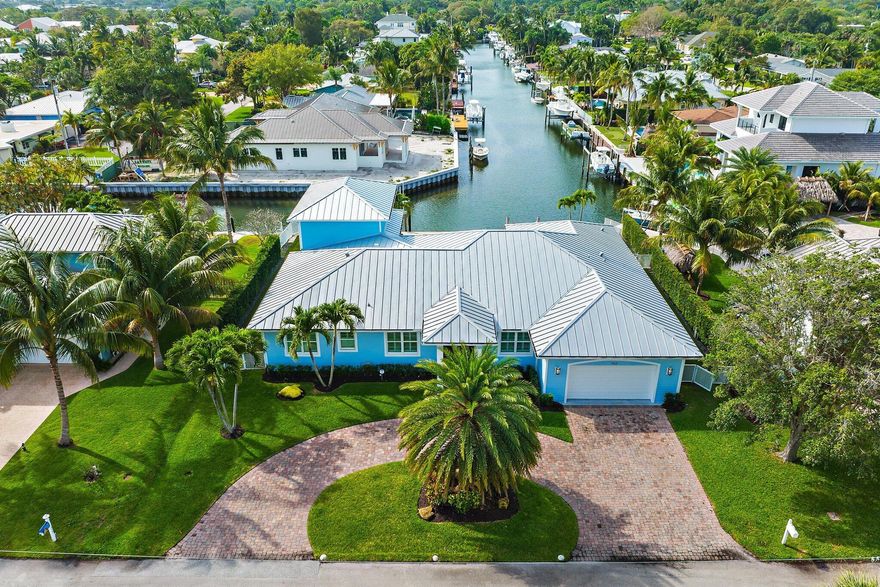 No HOA, bring your toys!  Move right into this beautiful waterfront home in the heart of Jupiter with quick access to the Loxahatchee River and Jupiter Inlet.   You'll love the long, south views down the canal, resort-like pool area, gas fire pit, covered patio with large island, built-in grill, 20k lbs boat lift and floating dock for 2 jet skis.  Interior upgrades include a complete renovation in 2014 featuring 4 bedrooms, 3.5 baths plus an office, complete hurricane impact windows and doors, 12ft ceilings, onyx kitchen counters and 100 bottle wine room in a great room layout.  2nd floor has 4th bedroom/loft area with views down the canal and room for a closet.  Backyard has artificial turf with 1000 gal buried propane tank and security cameras around the house.