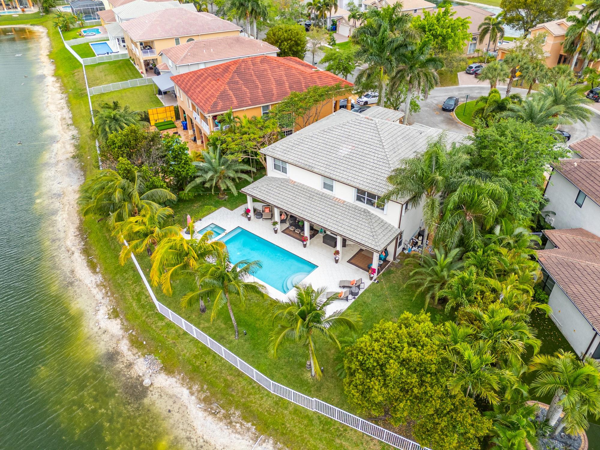 Exquisite two-story estate offers breathtaking lake views! Elegance abounds with hardwood floors, a gourmet island kitchen featuring Cambria Quartz counters and newer appliances. Entertainers dream, enjoy get togethers in the beautiful family room overlooking the tranquil pool area. The luxurious primary suite offers custom-designed his-and-hers closets, while all three bathrooms have been completely renovated with designer finishes. Brand-new heated saltwater pool & spa, fully controlled via the iAquaLink app. The covered patio boasts ceiling fans and a TV mount, perfect for entertaining. Upgraded ACs, EV charger, built-in garage storage, LED lighting. Sunset Lakes features resort-style amenities, including a clubhouse, fitness center, and tennis courts. Don’t miss this dream home!