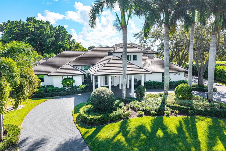 Welcome to an exceptional totally renovated 2021 Estate offering a refined living space in the prestigious Delray Dunes Golf & Country Club. Perfectly positioned on a .45-acre lot with southern exposure, this home enjoys commanding views of the 14th & 15th fairways. A circular driveway and porte cochère lead to a new glass entry door and a bright, open interior featuring soaring ceilings, a private elevator, and 48x48 porcelain tile throughout. The Chef's kitchen is built for grand entertaining with top-of-the-line appliances, oversized island, double dishwashers, new double ovens, commercial-grade refrigeration, and more. The great room, with electric fireplace and expansive sliders, flows seamlessly to the outdoor living spaces overlooking the course. A stunning glass-enclosed wine room with built-in cabinetry and champagne-inlay flooring adds a dramatic signature touch.
The first-floor primary suite includes a dedicated office/bonus room and spa-like bath with onyx waterfall double vanities, Jacuzzi tub with fireplace, large walk-in shower, and expansive custom closets. Upstairs, a wood staircase leads to a loft and two oversized guest suites, each with double-vanity baths, walk-in showers, and private access to a golf-view balcony. The outdoor areas are newly reimagined in 2021 and include multiple lounge spaces, a summer kitchen, upgraded pool/spa with fire feature, new pumps, salt system, electric awning, and lush privacy landscaping. Generac whole-home generator. A spacious 3-car garage plus golf cart area includes custom storage and a fully air-conditioned home gym with rubber flooring and a TV. A rare offering of design, craftsmanship, and breathtaking views all in a completely renovated 2021 estate.